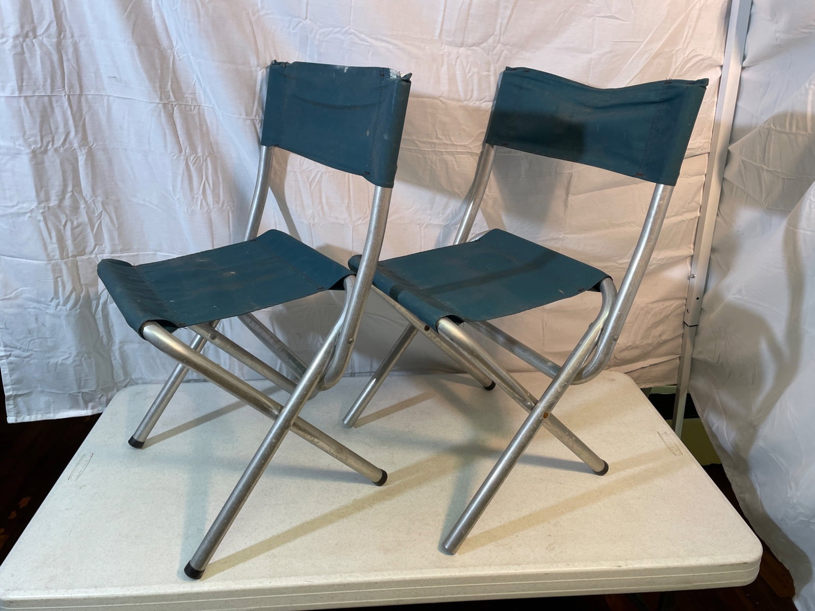 Folding Aluminum Chairs with Canvas Seats and Backs: This pair of folding chairs features lightweight aluminum frames with blue canvas seats and backs. The chairs are designed to be portable and foldable, offering convenience for transport and storage.