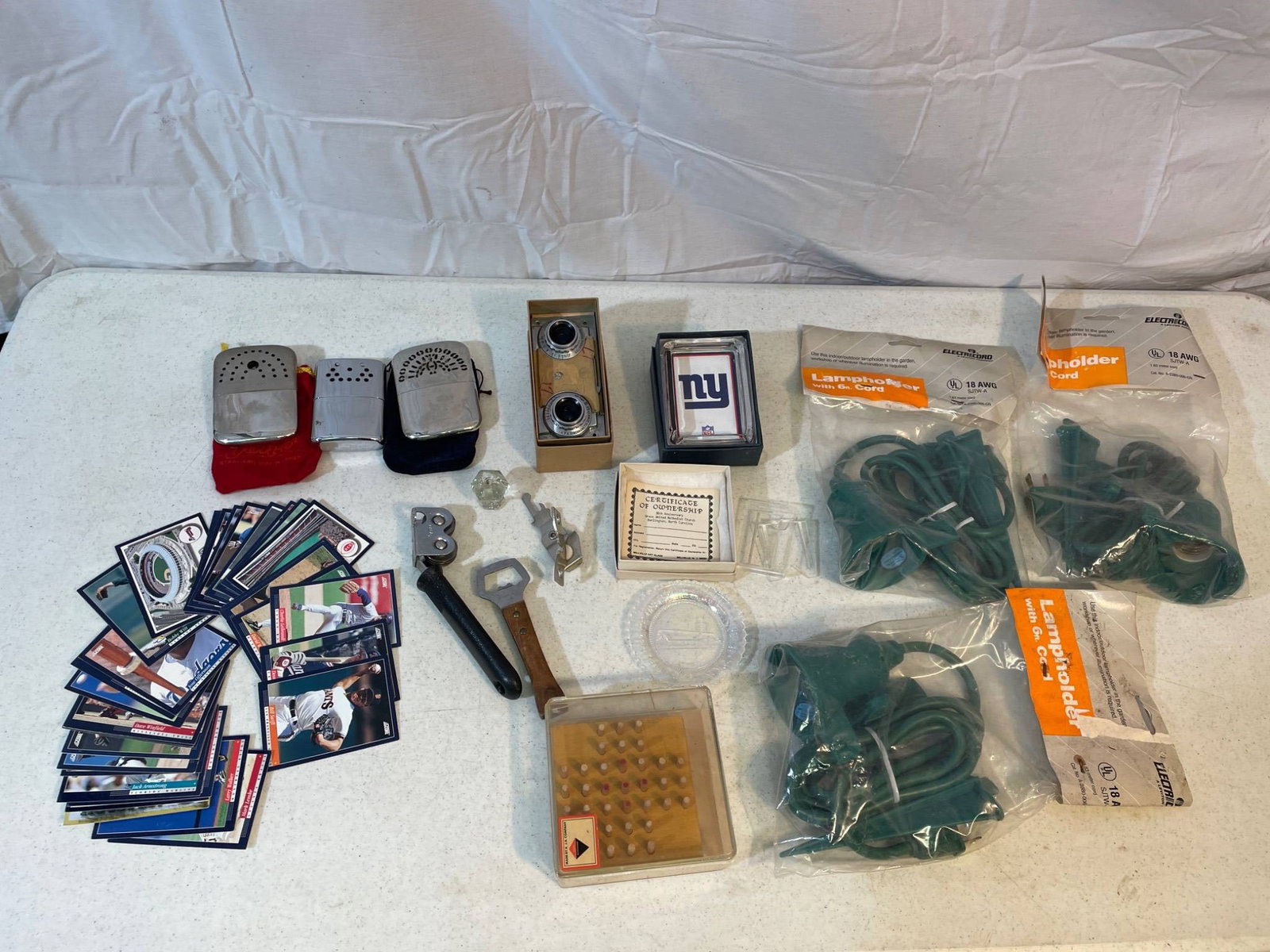 Collectibles and Miscellaneous Items, Including Cards and Tools: This lot includes an assortment of collectible and miscellaneous items: various sports trading cards, two reusable metal hand warmers, vintage tools such as a can opener and bottle opener, a set of ca