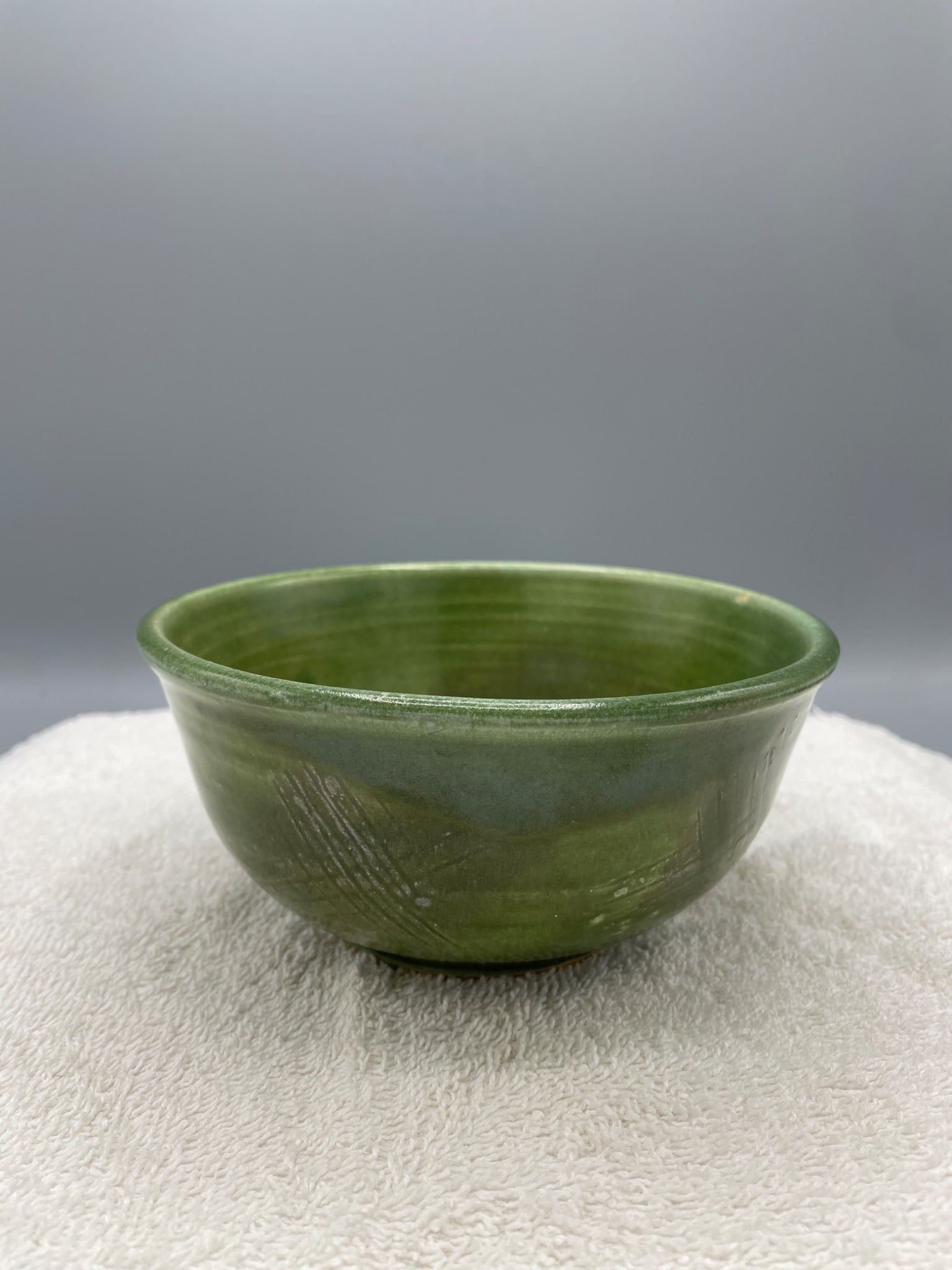 Green Ceramic Bowl With Signature and Date MD 1996: A small green ceramic bowl featuring a glossy finish and subtle etched patterns. The bottom is marked with 'MD 1996,' indicating the creator and year of manufacture. Approximate dimensions are shown