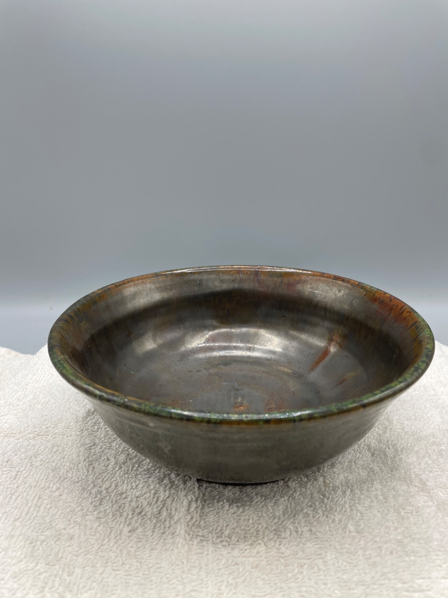 Handmade Ceramic Bowl with Signature and Date Inscription: A round ceramic bowl with an earthen glaze finish, featuring a clearly visible hand-inscription on the underside marked with initials 'LG' and the numerals '5-28'. The bowl measures approximately 2.5