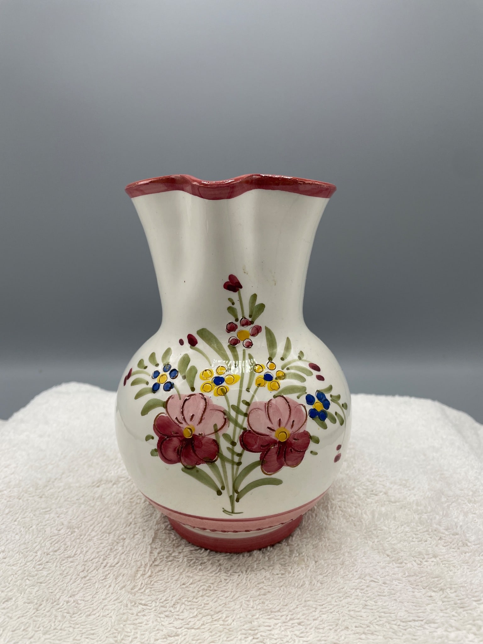 Hand-Painted Ceramic Pitcher with Floral Design - Marked 'Stresa': This is a hand-painted ceramic pitcher featuring a red handle and rim, as well as a floral motif on the body. The pitcher stands approximately 6 inches tall, as noted in the images. The bottom is mark