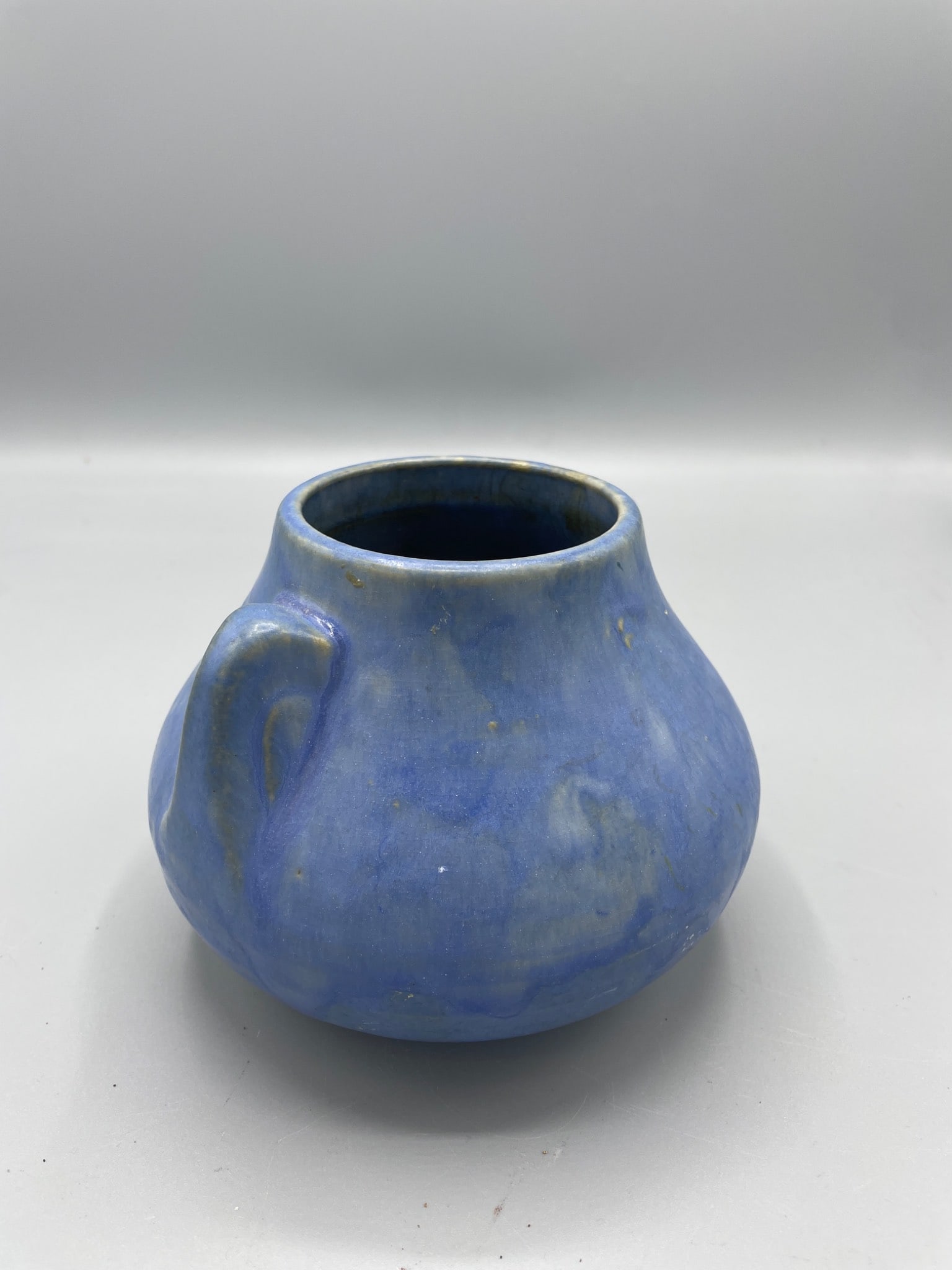 Brush McCoy Blue Vase with Handles, Approx. 4 Inches Tall: This is a blue vase attributed to Brush McCoy, featuring a blue glaze and measuring approximately 4 inches in height. The piece has small handles on both sides and displays signs of handcrafting. The
