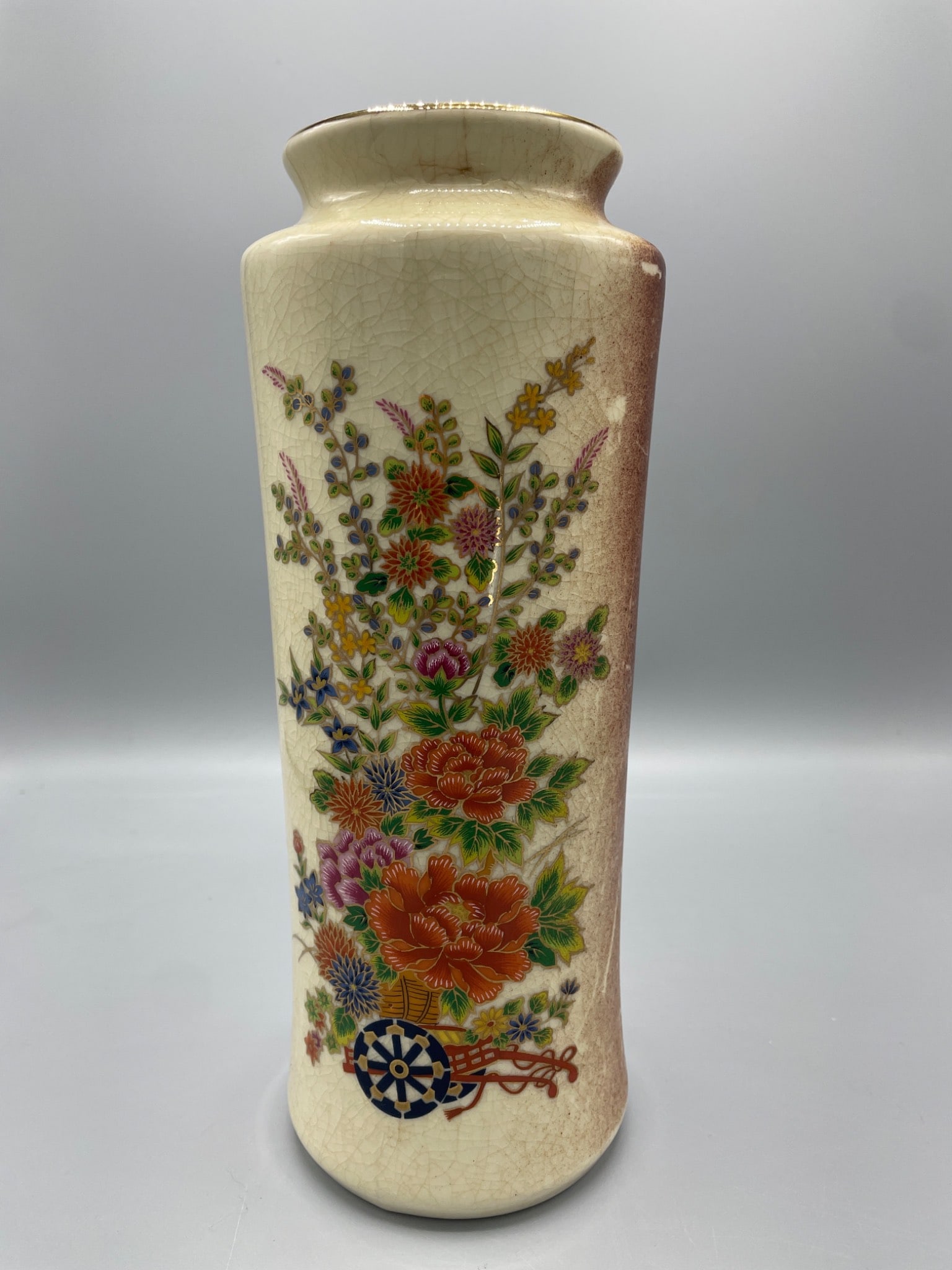 Japanese Ceramic Vase with Floral Design and Maker's Mark: This is a ceramic vase made in Japan, featuring a glazed floral design and crackle finish. The bottom bears a red stamp mark, as well as a sticker denoting it was made in Japan. The vase is