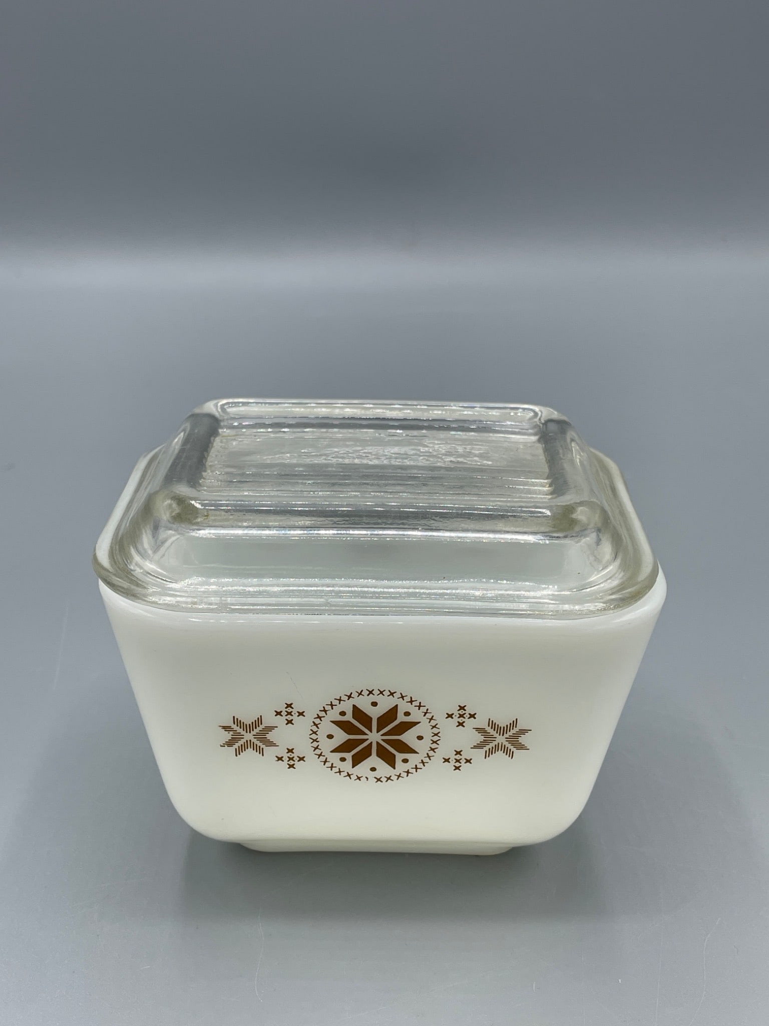 Pyrex 501-B 1 1/2 Cup Dish With Lid, Snowflake Design: Pyrex 501-B small refrigerator dish featuring a brown snowflake design on white milk glass. Includes the original clear ribbed glass lid. Marked on the base with '501-B 1 1/2 Cup, Pyrex, Made in