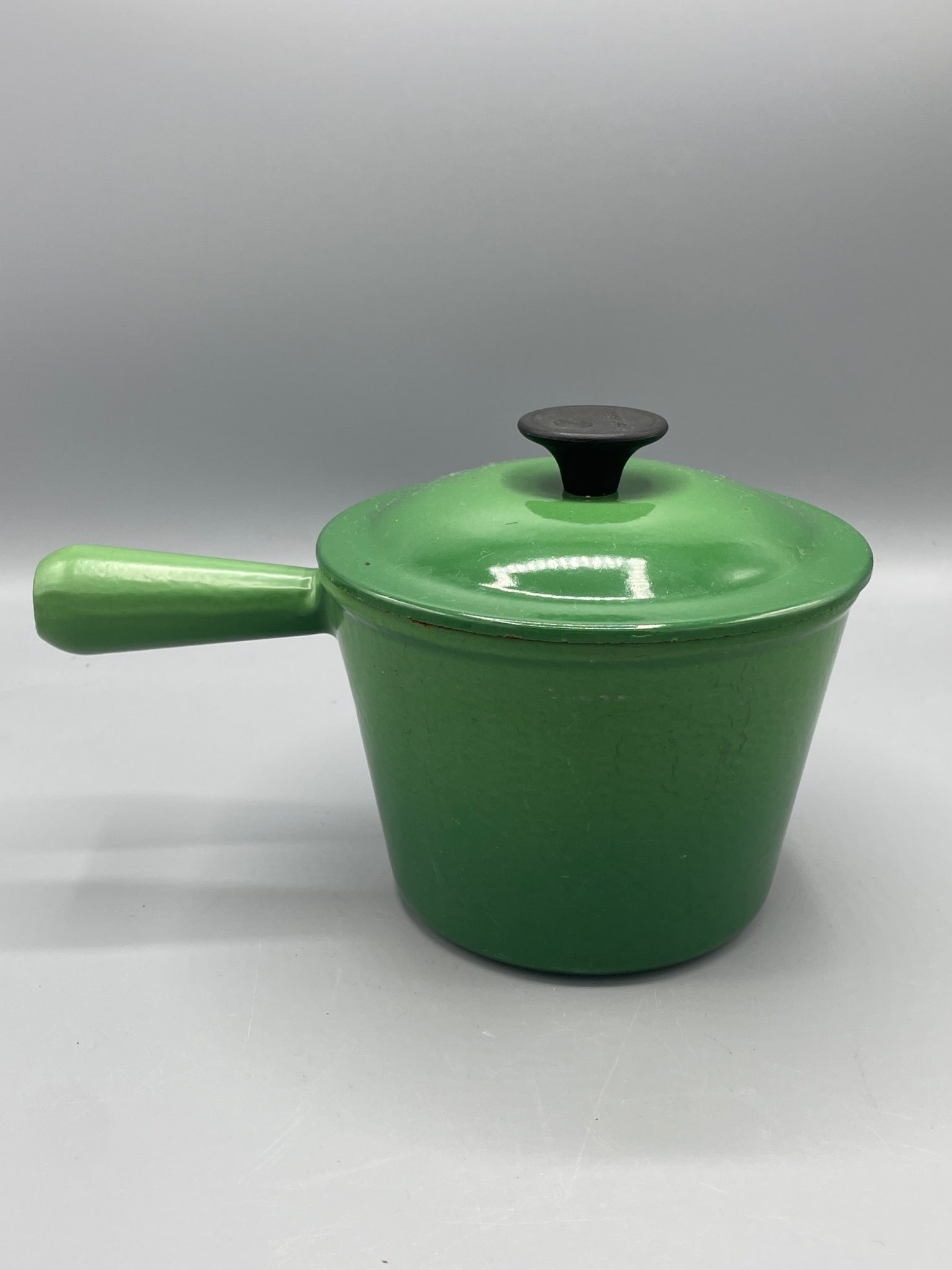 Le Creuset Green Enamel Cast Iron Saucepan with Lid and Wooden Knob: This is a Le Creuset green enamel cast iron saucepan with a wooden knob, marked 'Le Creuset' and 'Made in France' on the base and underside of the lid. It measures approximately 4.5 inches tall and fe