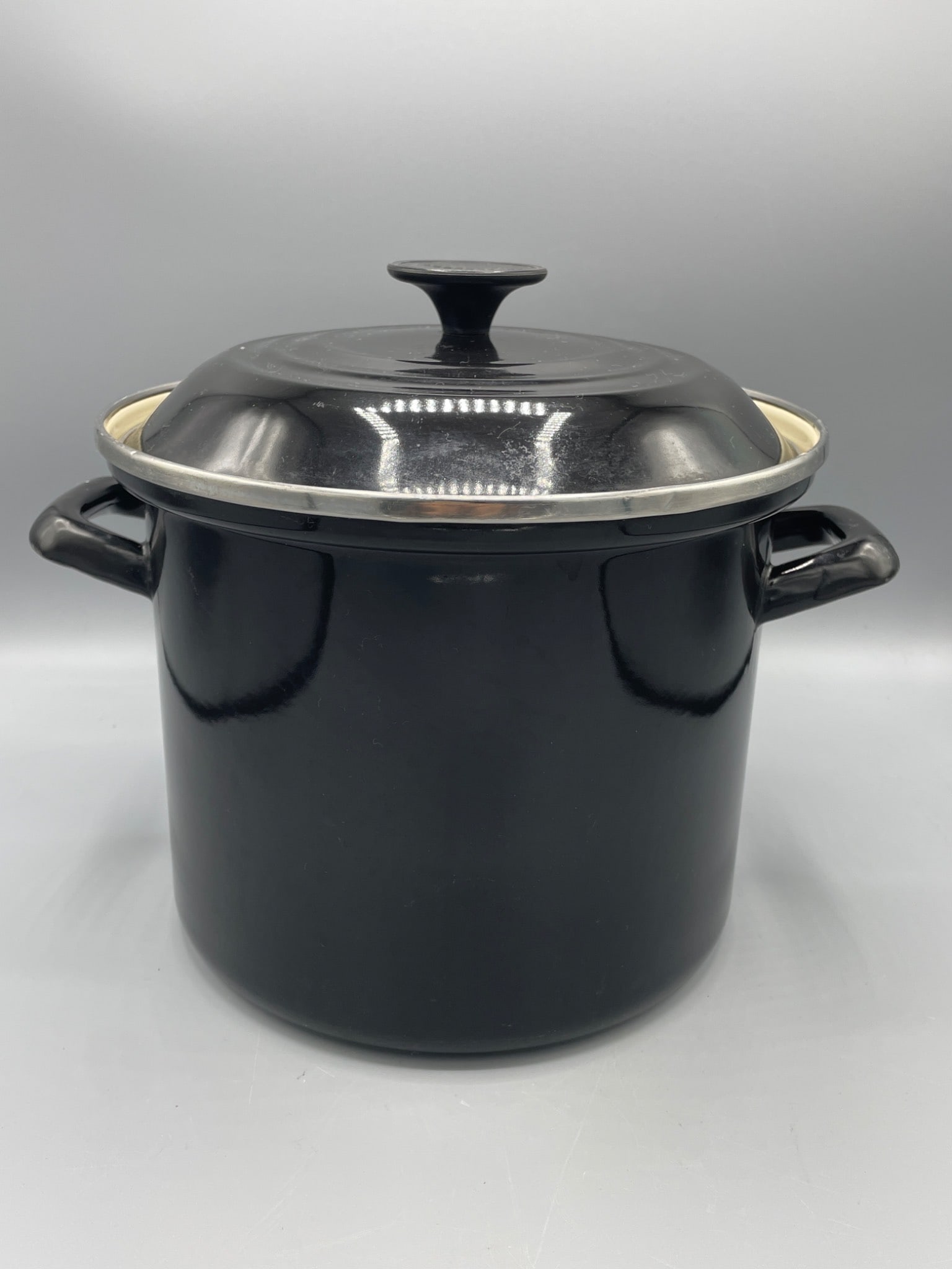 Le Creuset Enamel-on-Steel Stockpot with Lid, Black, Approx. 8-Inch Height: This is a Le Creuset enamel-on-steel stockpot in black, complete with its matching lid. The pot measures approximately 8 inches in height, as shown in the image with a ruler for reference. The interio