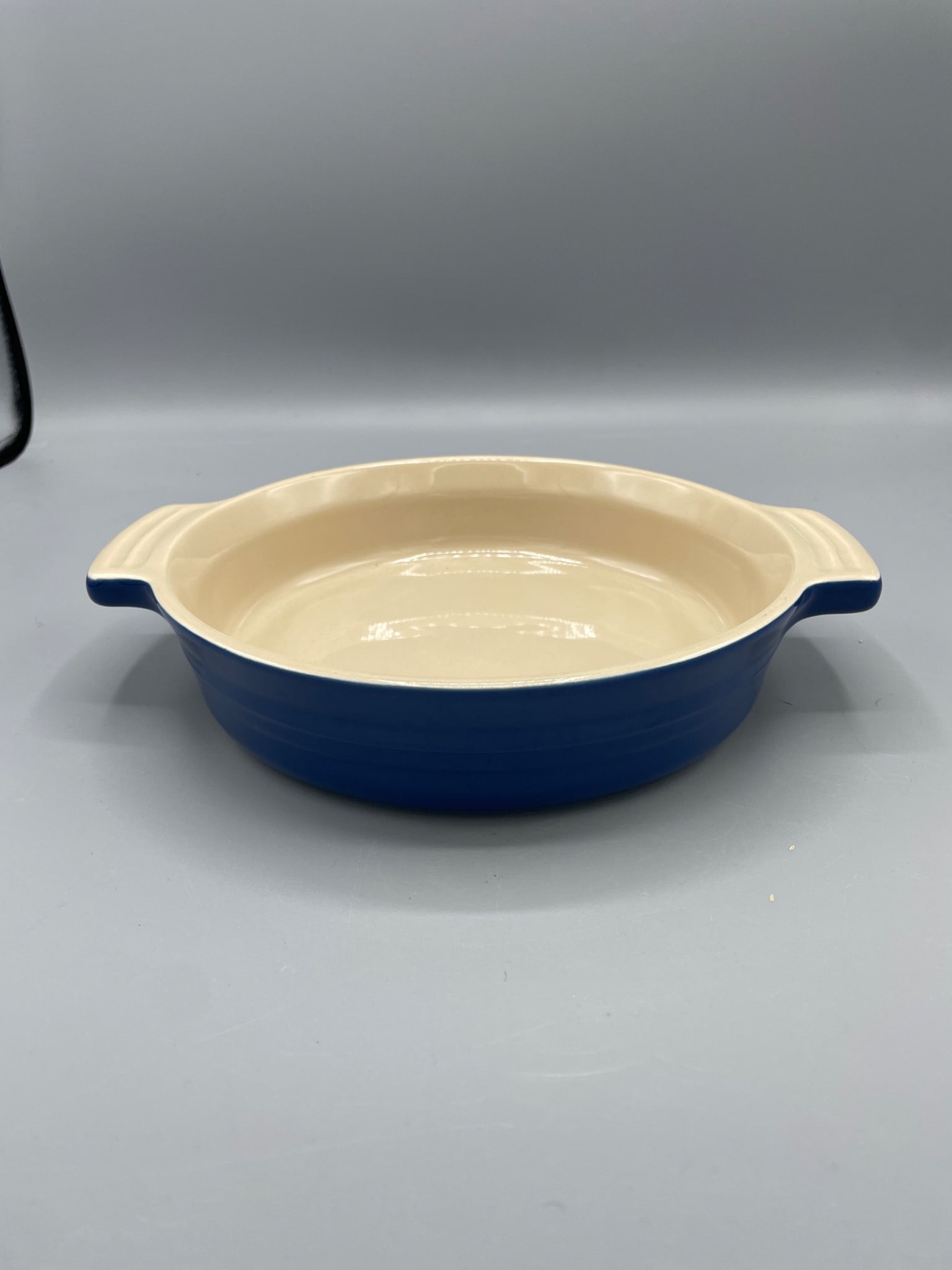 Le Creuset Stoneware 7-10 Baking Dish in Cobalt Blue: Le Creuset stoneware baking dish marked '7-10' on the underside, featuring a cobalt blue exterior and cream interior. The dish has dual handles and measures approximately 2 inches in height. Suitable