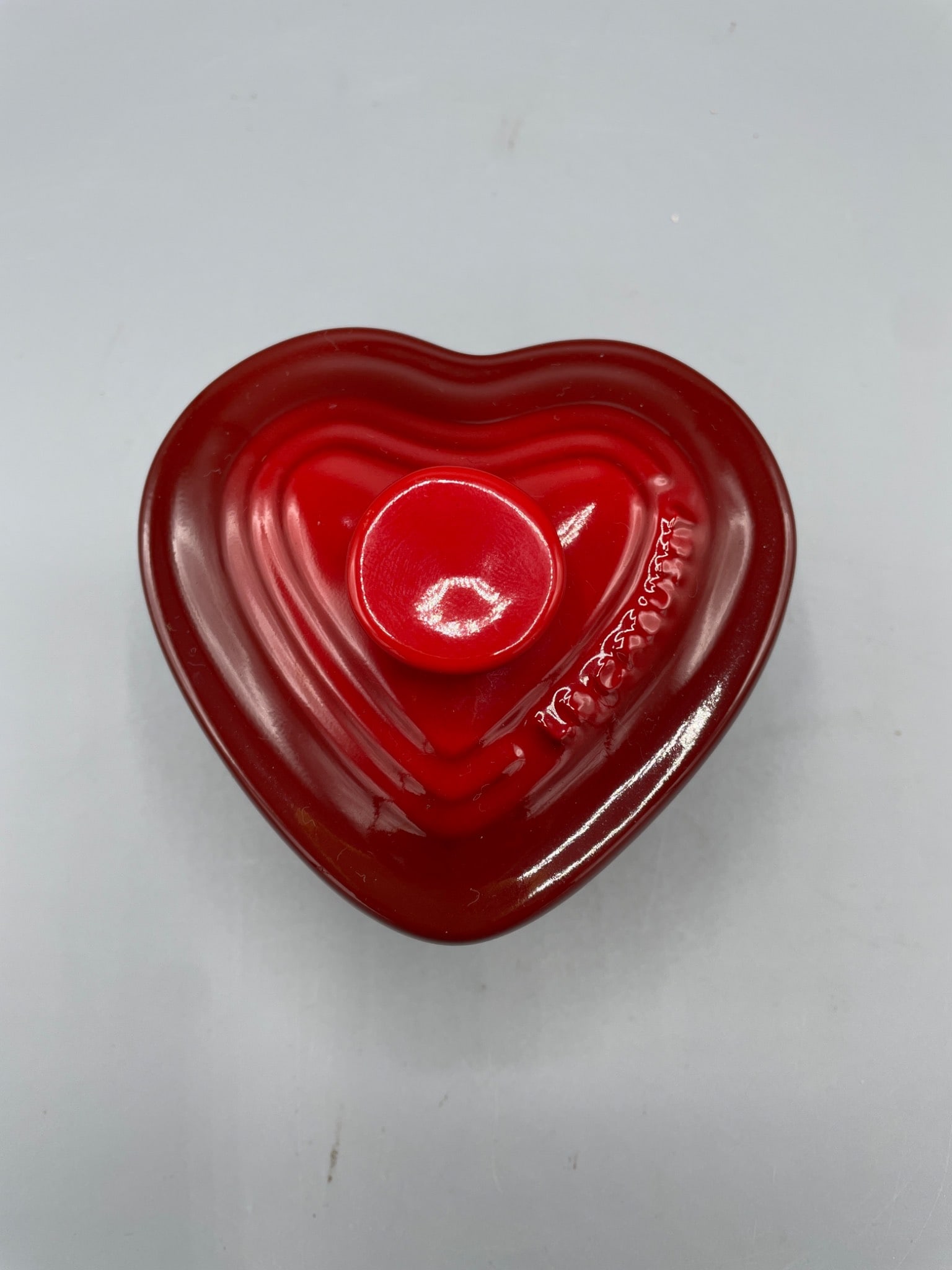 Le Creuset Small Covered Heart Ramekin in Red, Model PG910031-1067: Le Creuset small covered heart-shaped ramekin with lid in red, model PG910031-1067. Manufactured in 2008, this ceramic dish features an enamel coating and is microwave, oven, and dishwasher safe. The