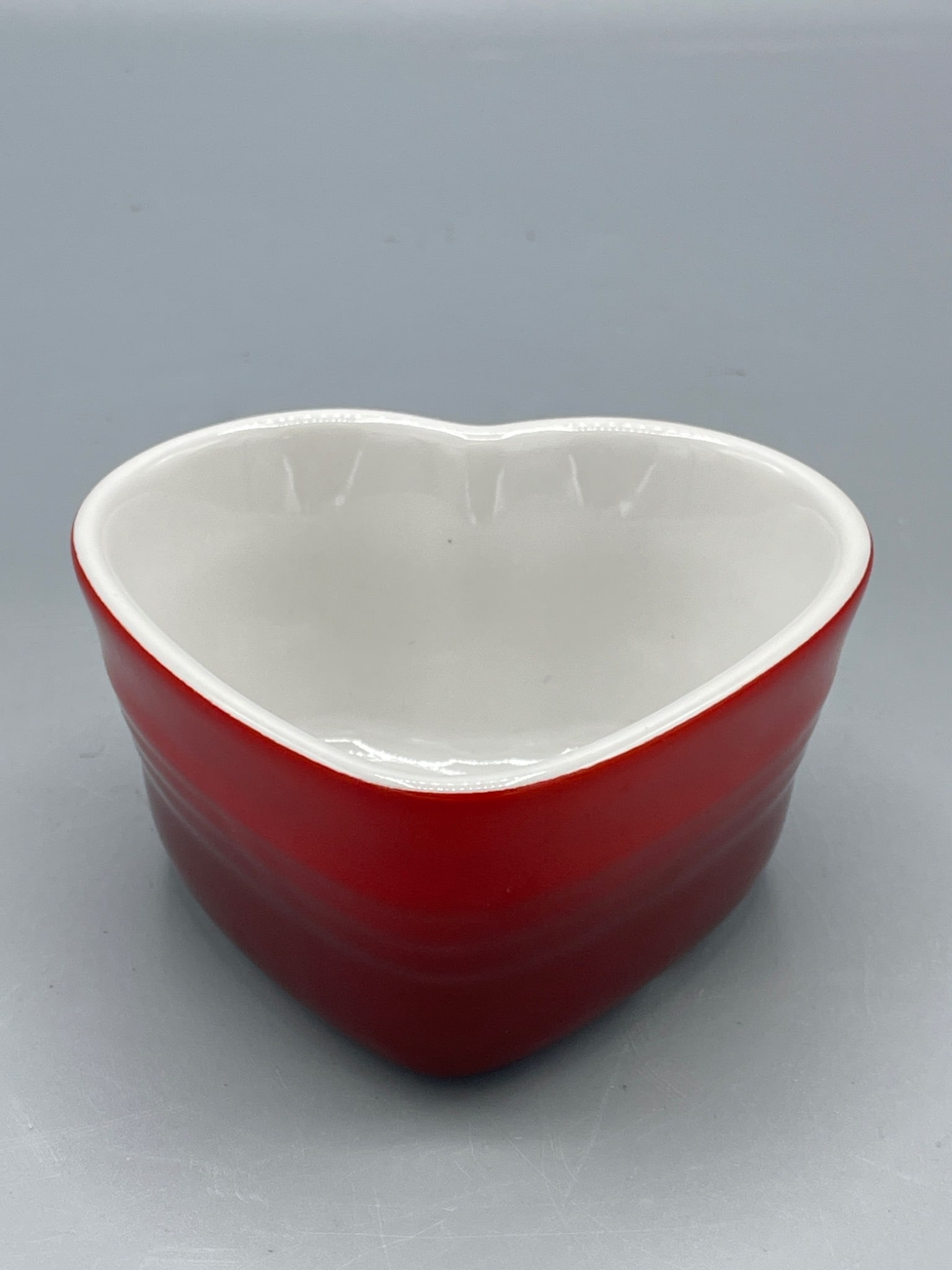 Le Creuset Small Covered Heart Ramekin, Red and White: Le Creuset Small Covered Heart Ramekin in a red and white color scheme. The bottom is marked with a label reading â€˜Le Creuset 08 Small Covered Heart Ramekin.â€™