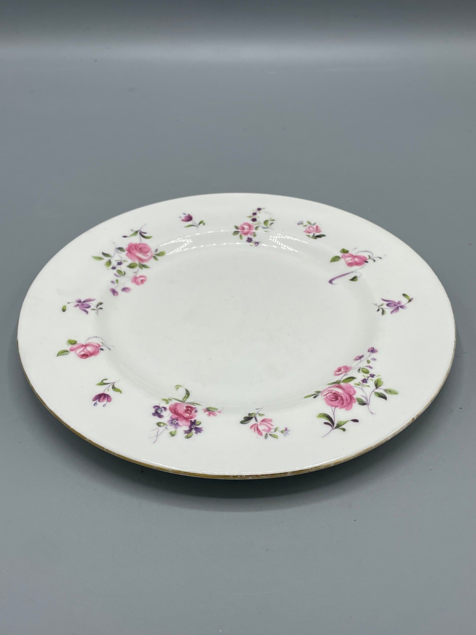 Crown Staffordshire Floral Plate, Made in England, Est. 1801: This lot features a porcelain plate created by Crown Staffordshire, established in 1801, as indicated by the backstamp. The plate has a floral design with roses and other flowers, gold trim along the