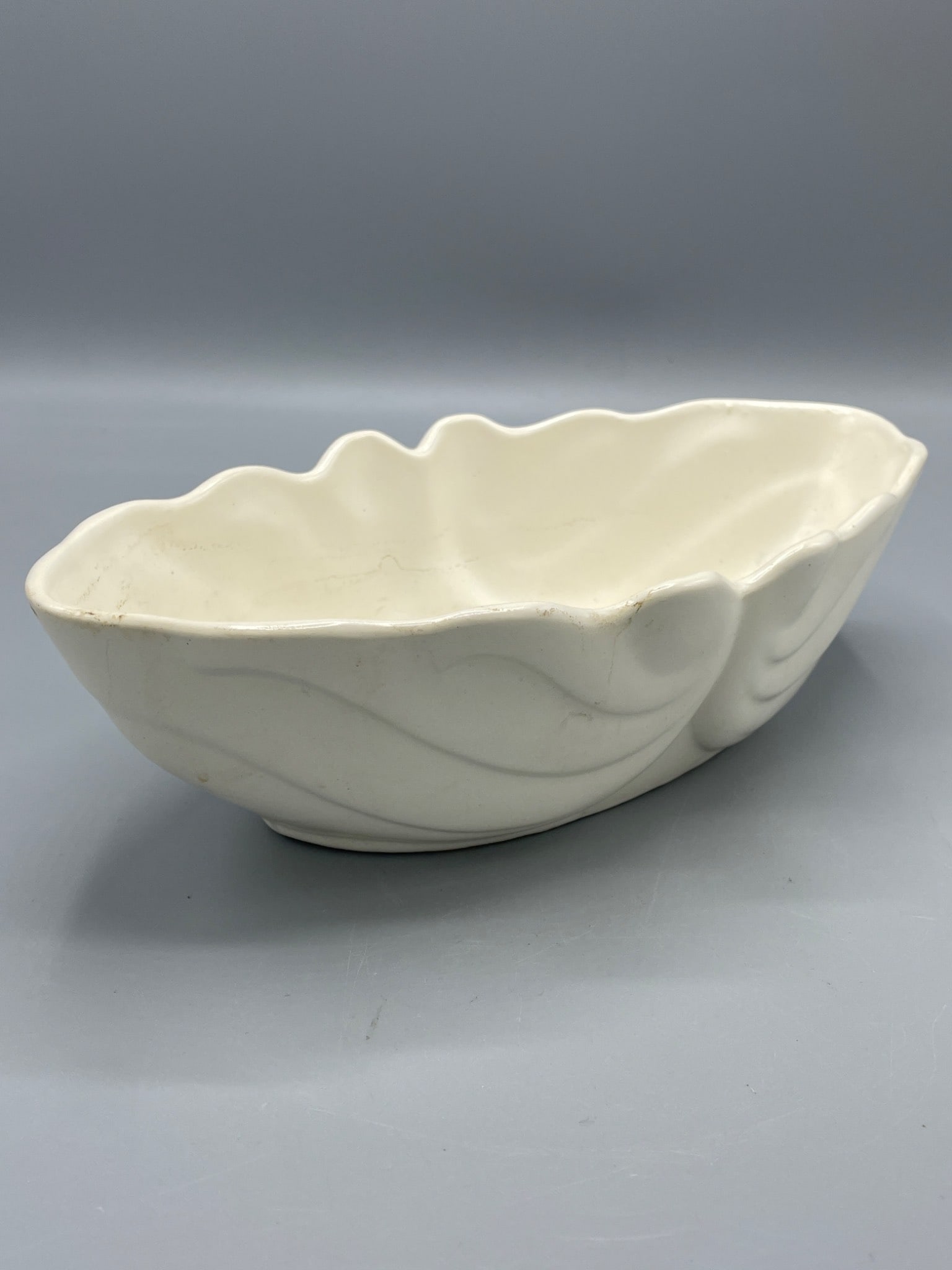 Hull USA F77 Ceramic Dish: This is a ceramic dish marked Hull USA with model number F77 impressed on the base. It measures approximately 11.5 inches in length and 4 inches in height. The dish features a wavy, scalloped rim and