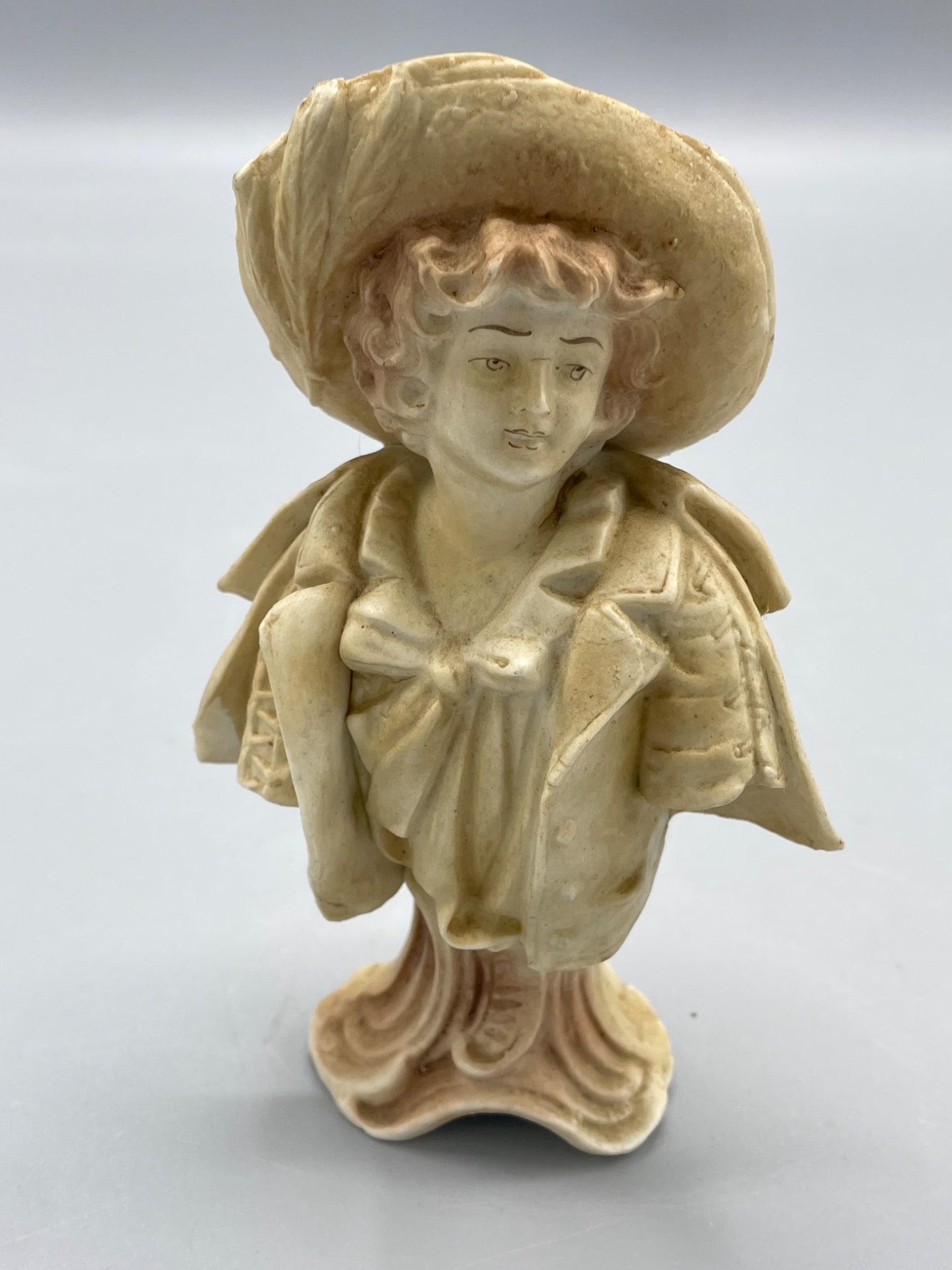 Porcelain Figurine of a Person Wearing Hat and Jacket on a Pedestal Base (1 of 5)