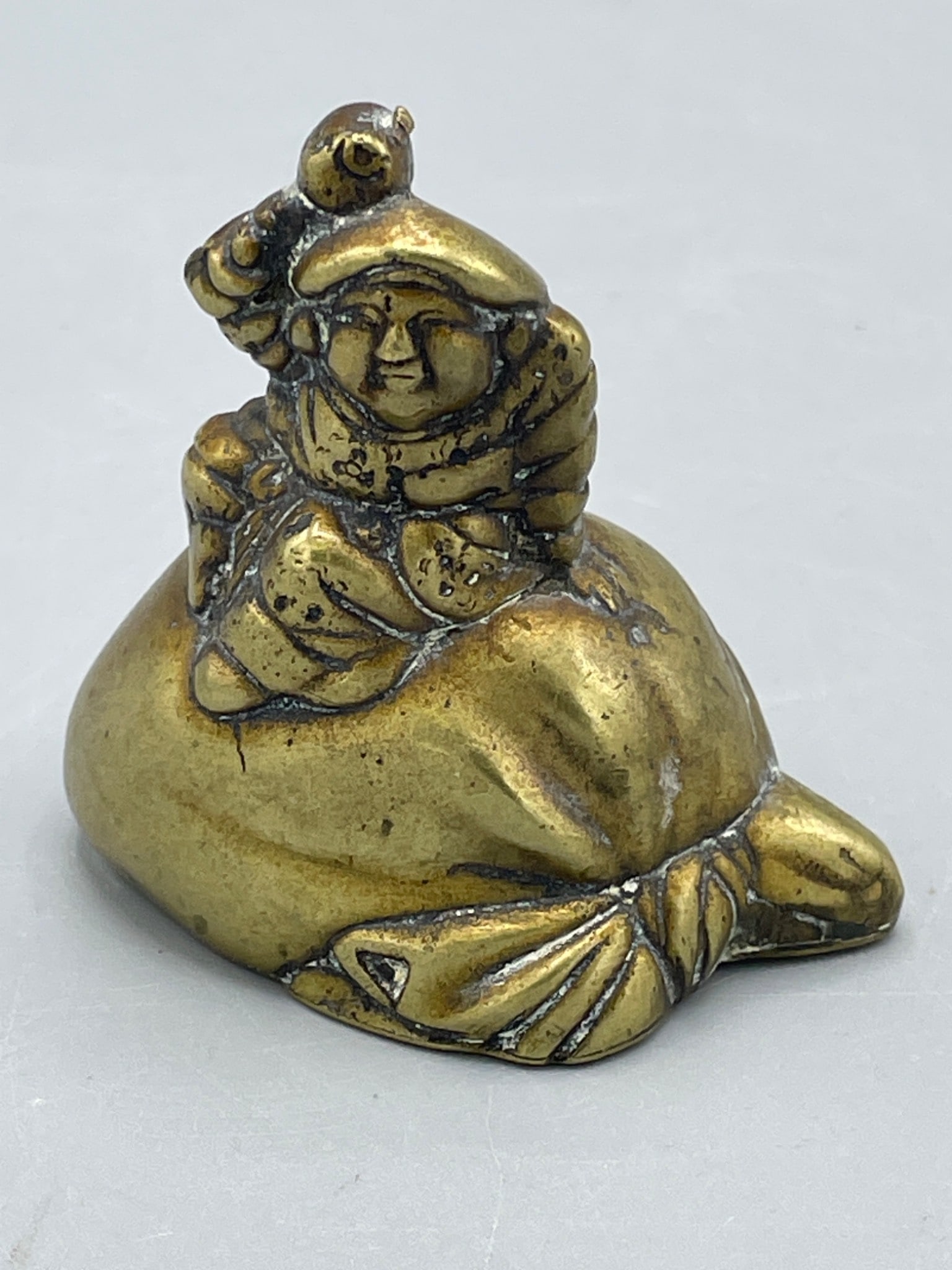 Brass Figurine Depicting a Man on a Bag-Shaped Base (1 of 4)