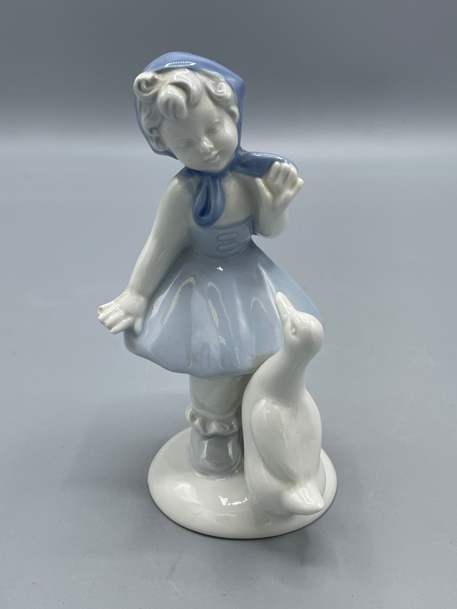 Porcelain Figurine of Girl with Goose, Model G710B, Made in Western Germany: This porcelain figurine, marked with model number G710B, depicts a girl with a goose. The underside contains a hallmark indicating it was made in Western Germany. The piece measures approximately 5.5
