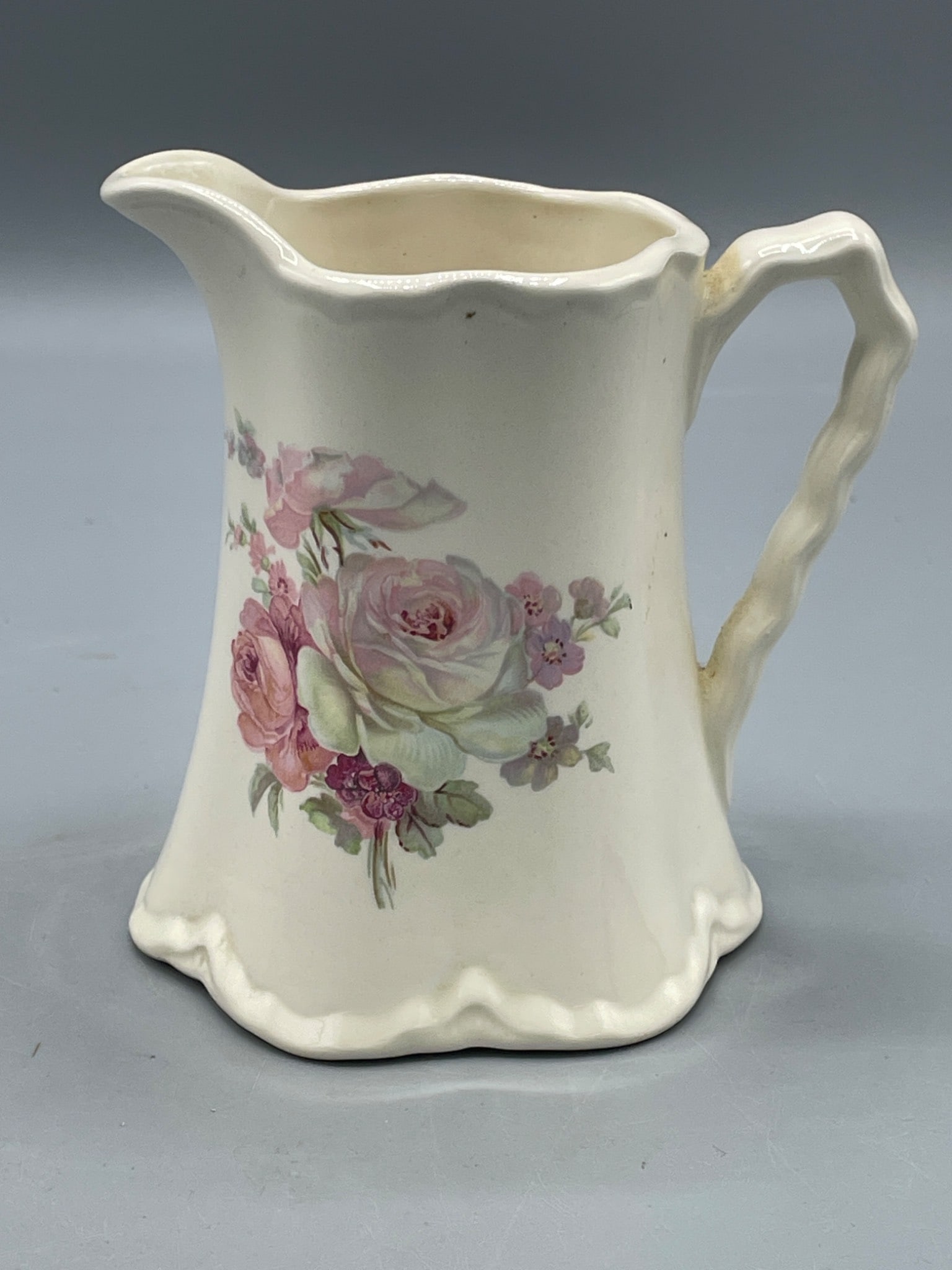 Colonial Mold USA Creamer Model 305 with Floral Design, 1937: Cream-colored ceramic creamer marked 'Colonial Mold USA 305' and dated 1937 on the underside. Features a floral design with multi-colored roses on the exterior. The piece measures approximately 5 inch
