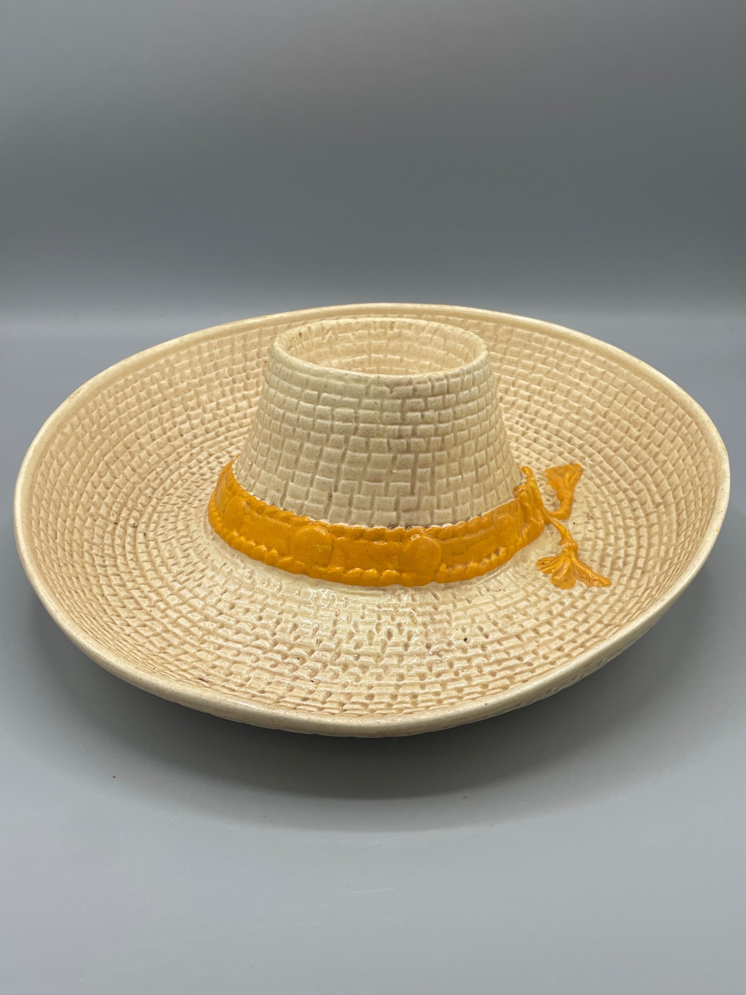 Ceramic Chip and Dip Bowl Hat Shaped, Marked 1986 Made in USA: This is a ceramic chip and dip bowl designed in the shape of a hat. It features a textured surface resembling woven straw and a painted band detail. The base of the bowl is marked 'W.P Â© 86