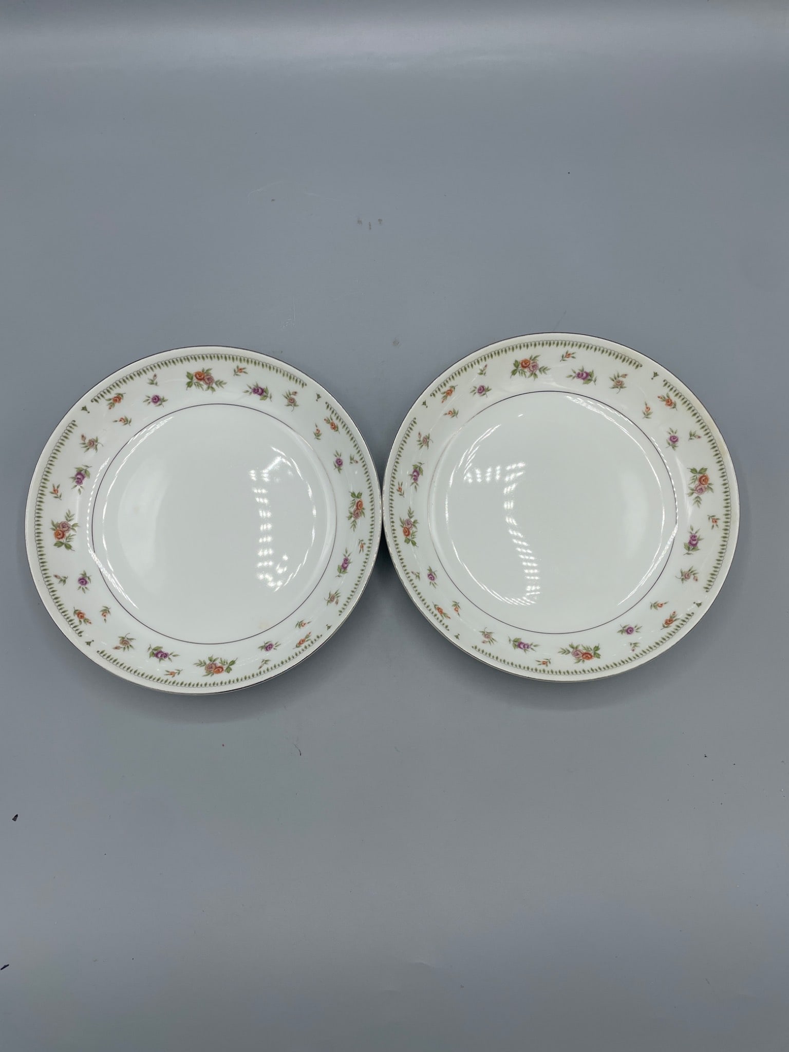 Abingdon Fine Porcelain China Bowls Made in Japan: This lot features a pair of Abingdon Fine Porcelain China bowls made in Japan. Each bowl is decorated with floral patterns and green accents along the rim. The bowls measure approximately 7.5 inches i