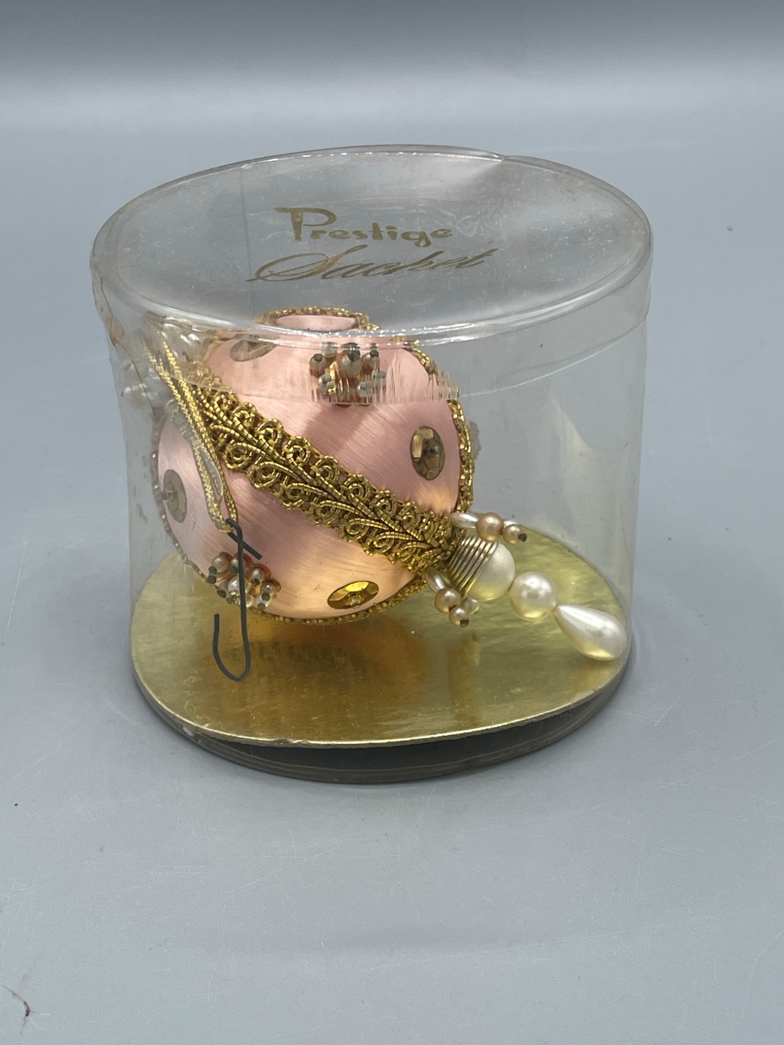 Prestige Sachet Ornament in Original Packaging with Gold Accents: This item is a Prestige Sachet ornament featuring decorative gold accents and bead embellishments. It is encased in its original transparent plastic packaging marked 'Prestige Sachet.' The ornament