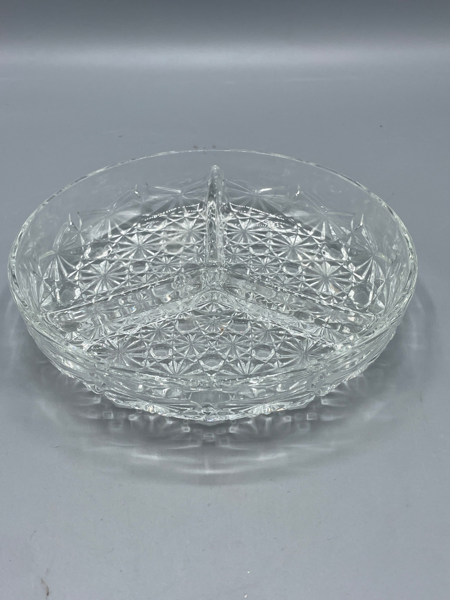 Three-Section Crystal Bowl With Geometric Pattern: A three-section crystal bowl featuring a geometric pattern with dividing ridges for separation. The bowl has a diameter of approximately 6.5 inches and a height of 2.5 inches. Ideal for serving or