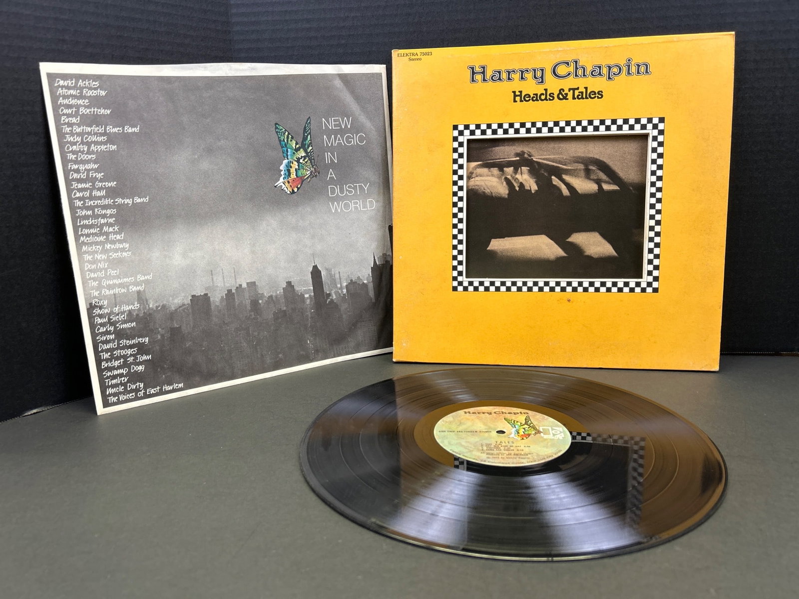Harry Chapin 'Heads & Tales' Vinyl Record with Gatefold and Inserts: This lot includes a vinyl record of 'Heads & Tales' by Harry Chapin. The pressing is on Elektra Records, catalog number EKS-75023. Features original gatefold jacket with die-cut cover and inserts.