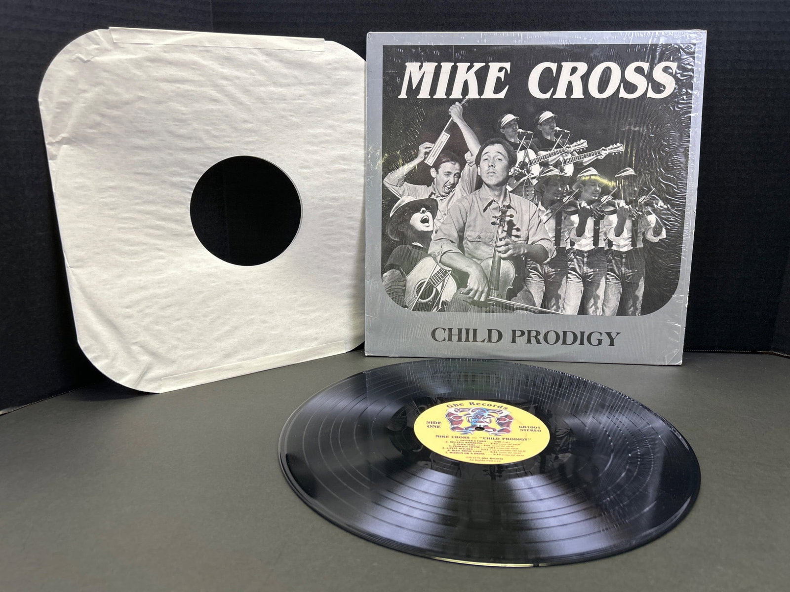 Mike Cross 'Child Prodigy' Vinyl Record with Original Sleeve: The vinyl record titled 'Child Prodigy' by Mike Cross includes its original cover and sleeve. The record label reads 'Still Records' with catalog number SLP-1003. The condition of the vinyl and cover
