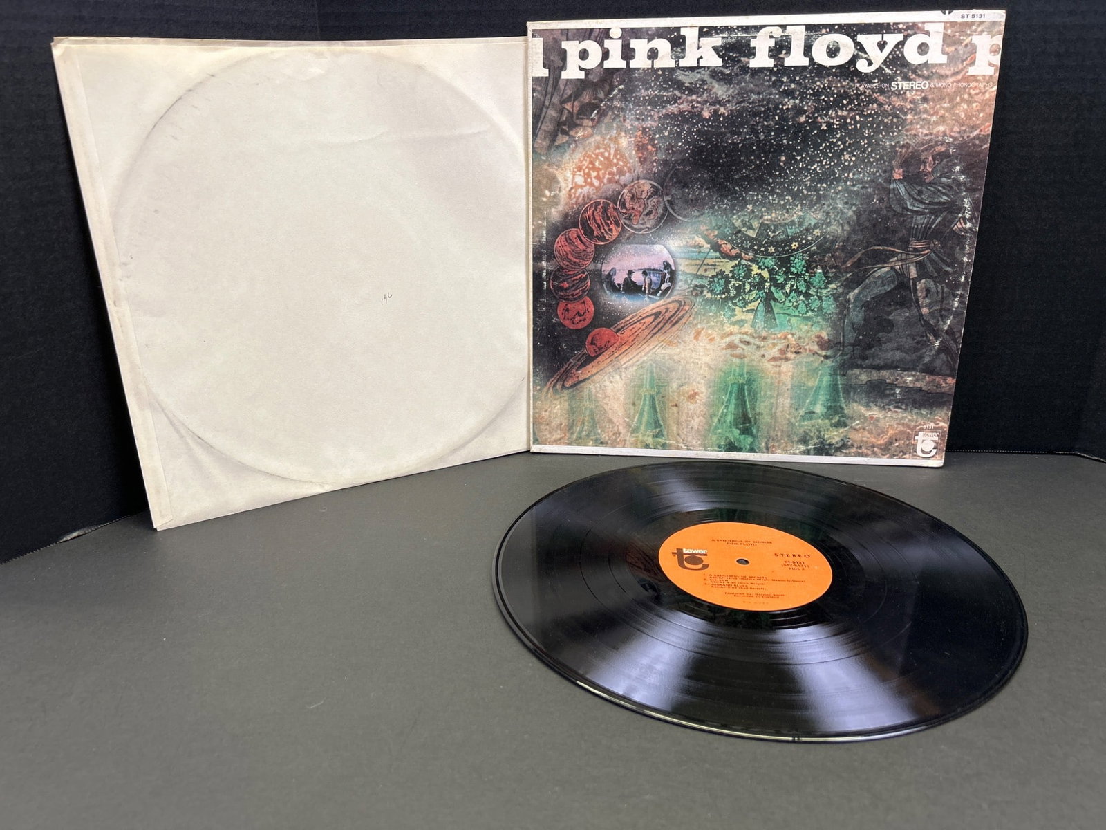 Pink Floyd 'A Saucerful of Secrets' Vinyl LP with Original Sleeve: This listing features the vinyl record 'A Saucerful of Secrets' by Pink Floyd. The album appears to be an original pressing with its accompanying artwork sleeve. The record has an orange label and
