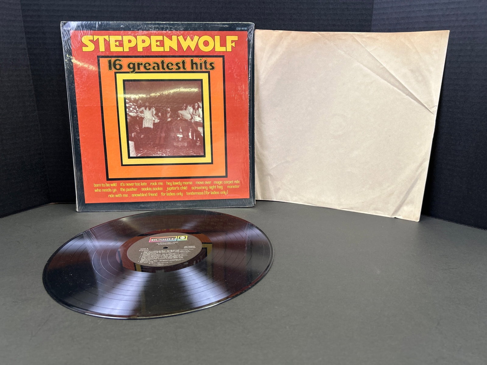 Steppenwolf '16 Greatest Hits' Vinyl Record Album With Sleeve: This is a vinyl record album, titled 'Steppenwolf: 16 Greatest Hits', released by Dunhill/ABC Records. The catalog number is DSX 50135. Includes the original record sleeve with minimal markings. The c
