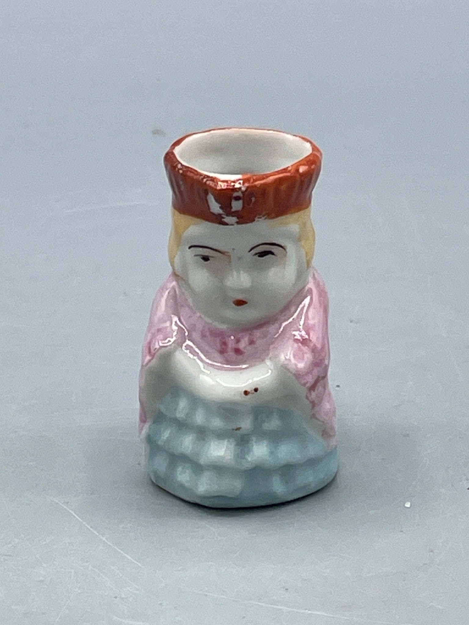 Small Porcelain Figurine Creamer with Hand-Painted Design, Marked 'Made in Japan': This is a small porcelain figurine creamer styled as a person in traditional clothing. The creamer is hand-painted in vivid colors. The base features printed marks reading 'Made in Japan.' The item