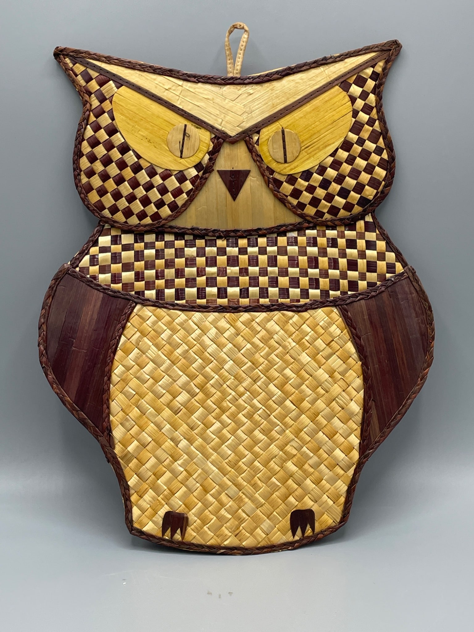 Interpur Owl-Shaped Woven Wall Decoration, Made in China: This is a woven owl-shaped wall decoration labeled 'Made in China' by Interpur. The front features a woven design in shades of yellow and brown, while the reverse shows a solid red backing. It
