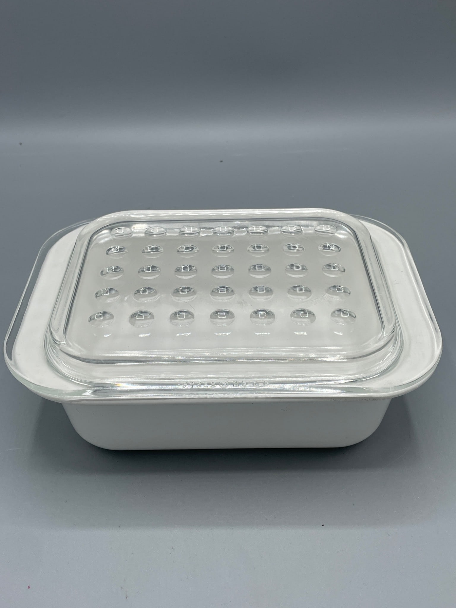 Corning Ware MC-1-B Baking Dish with Clear Glass Lid, 7x5.5x2 Inches: This is a Corning Ware MC-1-B baking dish featuring a white ceramic body and a clear glass lid with a dot pattern design. The dish measures 7x5.5x2 inches and is labeled as safe for oven and