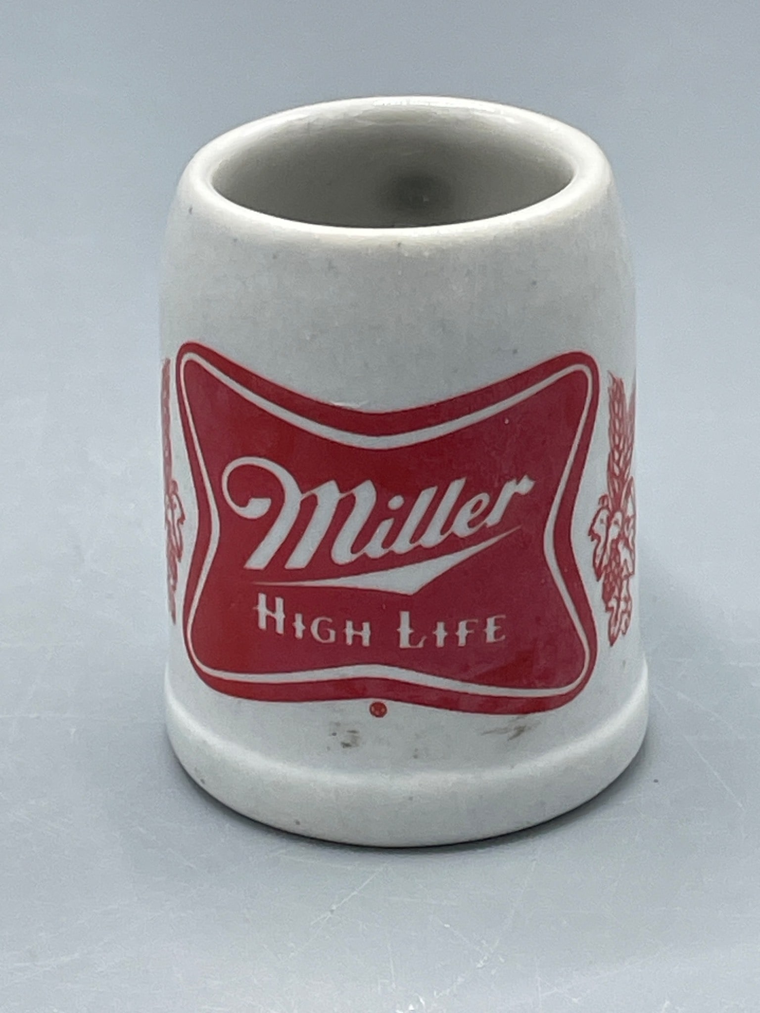 Ceramarte Made in Brazil Miller High Life Ceramic Beer Mug: Small ceramic beer mug designed and manufactured by Ceramarte in Brazil. Features the red and white 'Miller High Life' logo and wheat graphics on the exterior. Approximate height is 2.5 inches as