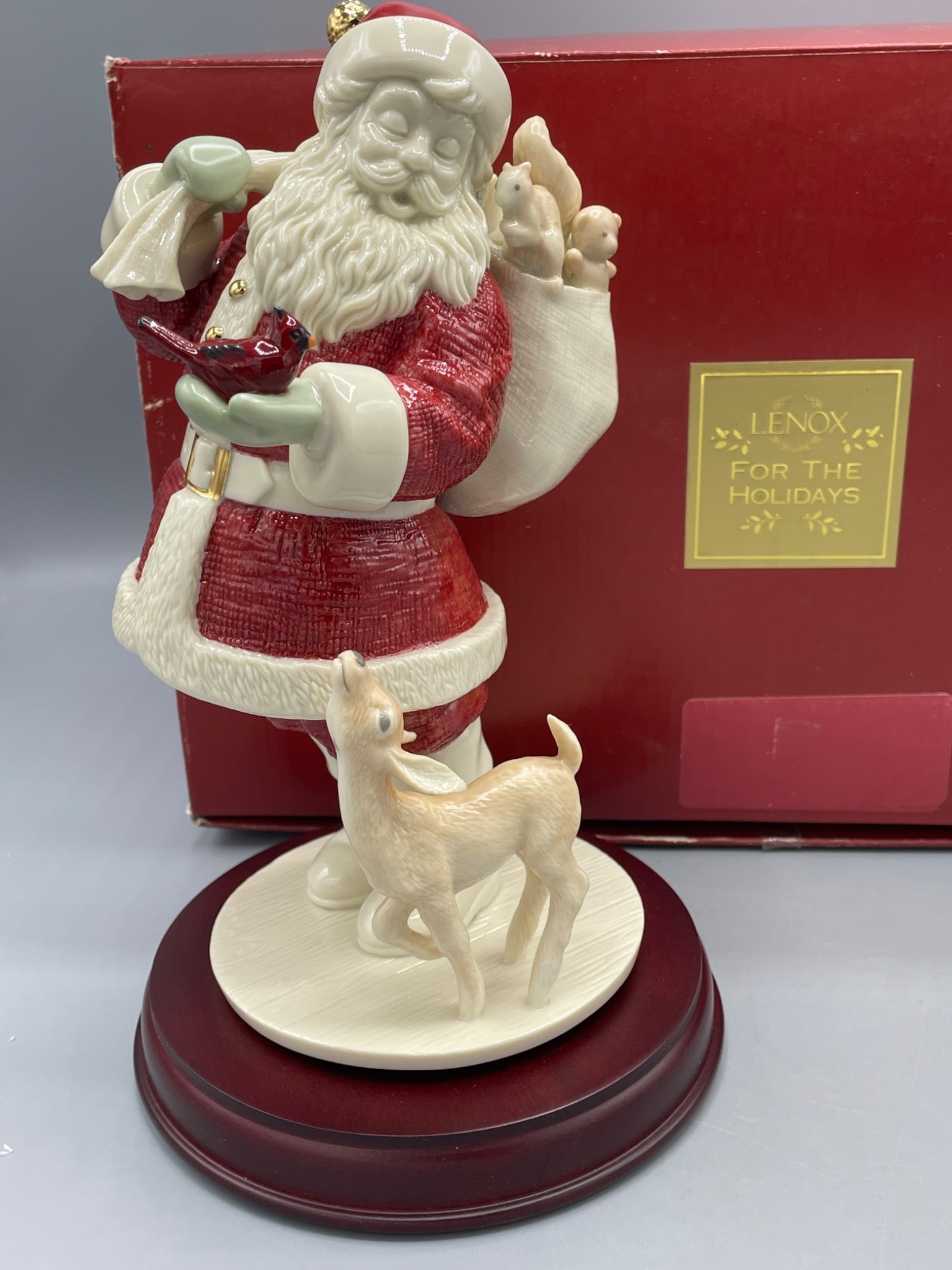 Lenox Santa and Friends Holiday Figurine SKU# 6188924: Lenox holiday figurine titled 'Santa and Friends,' manufactured in Thailand with SKU# 6188924. The piece is crafted with fine details, featuring Santa holding a bird, accompanied by a reindeer, and in