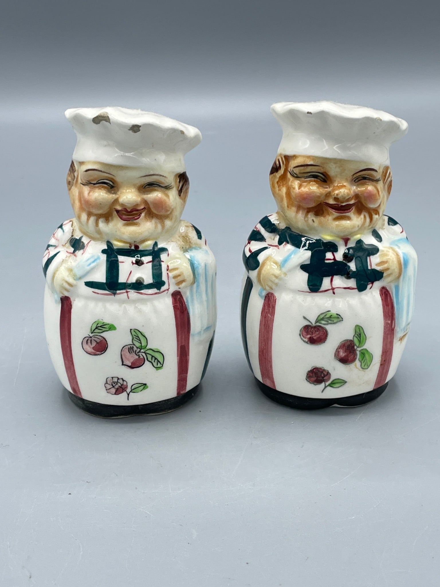 Porcelain Salt and Pepper Shakers with Chef Motif and Maker's Mark (WK): Porcelain salt and pepper shakers featuring chef figure designs. The bottom of each shaker has a maker's mark reading 'WK.' Each shaker measures approximately 4 inches in height. Both pieces display