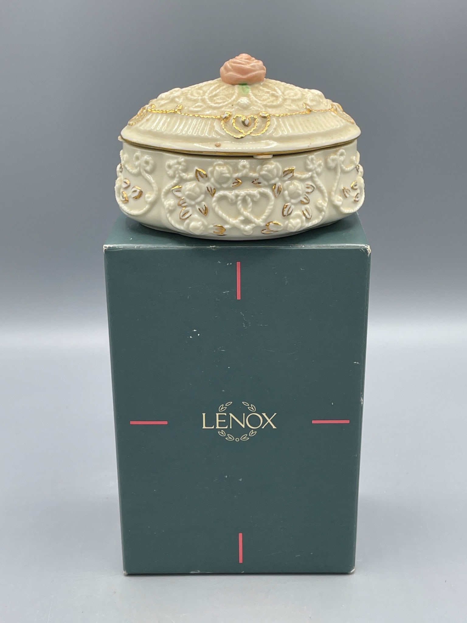 Lenox Songs of the Heart Endless Love Music Box, 1995: This is a Lenox Songs of the Heart Endless Love Music Box made of fine porcelain. It was handcrafted in Malaysia in 1995. The piece features intricate gold accents and a rose-topped lid. It is accompa