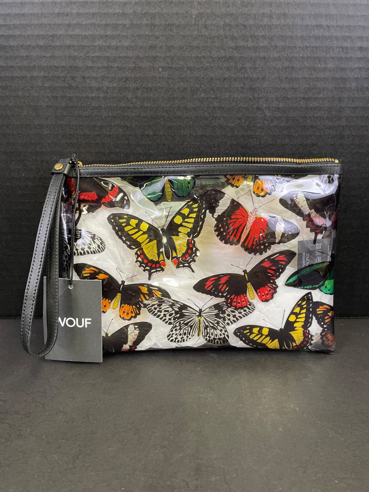 Wouf Papillon Vinyl Wristlet Clutch With Butterfly Print: Wouf Papillon Vinyl wristlet clutch featuring a butterfly motif. Designed and produced in Barcelona using high-quality Italian nylon, with finishes made from Spanish leather. Includes original tag.