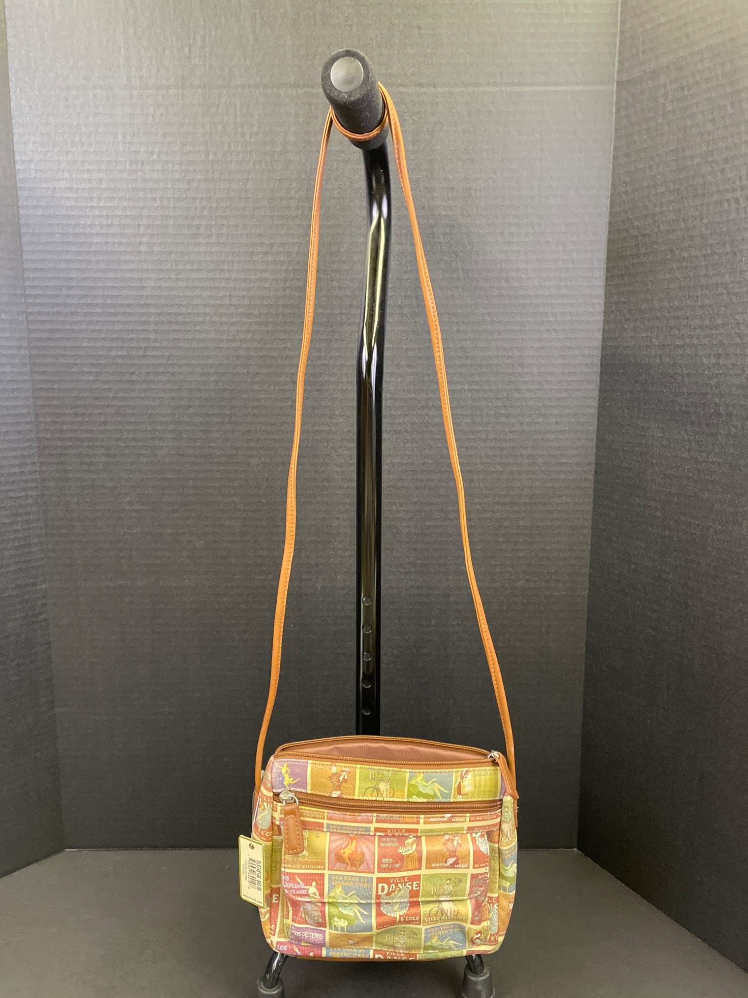 Fossil SL87448190 Leather Zip Mini Crossbody Bag: Fossil leather zip mini crossbody bag with a multicolor printed fabric design featuring dancing figures and a leather bottom. Model number SL87448190 as indicated on the tag. Features a single