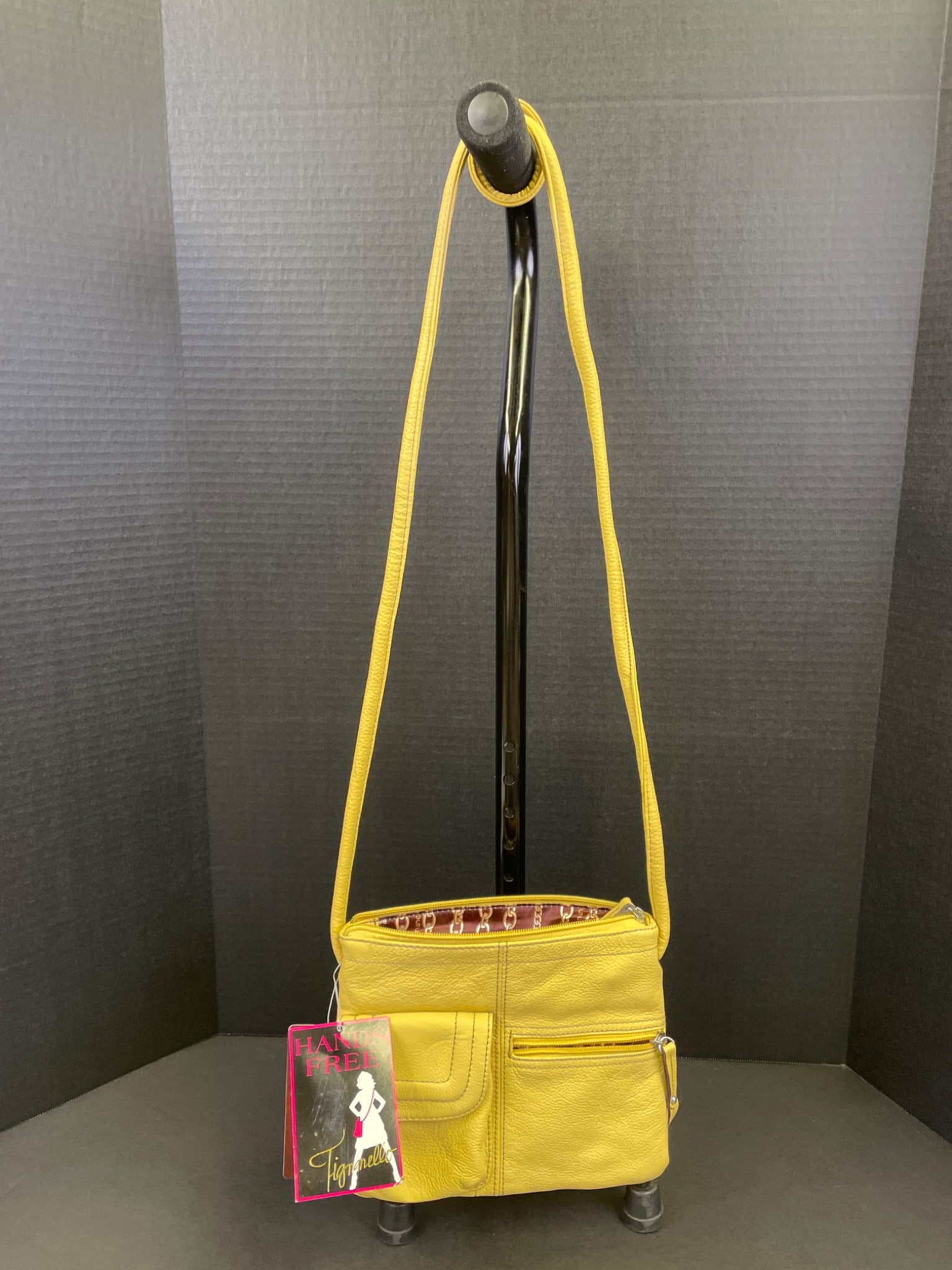 Figatello Hands-Free Yellow Crossbody Bag With Chain-Pattern Lining: Figatello yellow crossbody bag featuring a hands-free design. Includes original brand tags. Made of pebbled material with multiple external zippered compartments and adjustable strap. Interior is