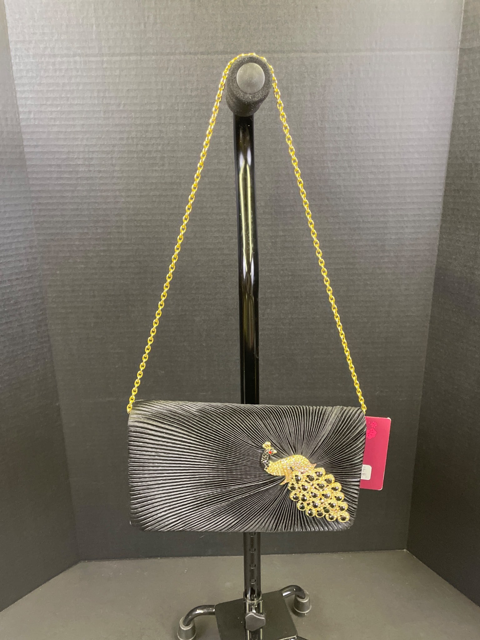 Lulu Townsend Black Satin Clutch With Gold-Tone Chain And Peacock Ornamentation: This Lulu Townsend satin clutch features a sleek black exterior and a gold-tone chain strap, complemented by a peacock-shaped ornament with decorative accents. The item includes original tags and