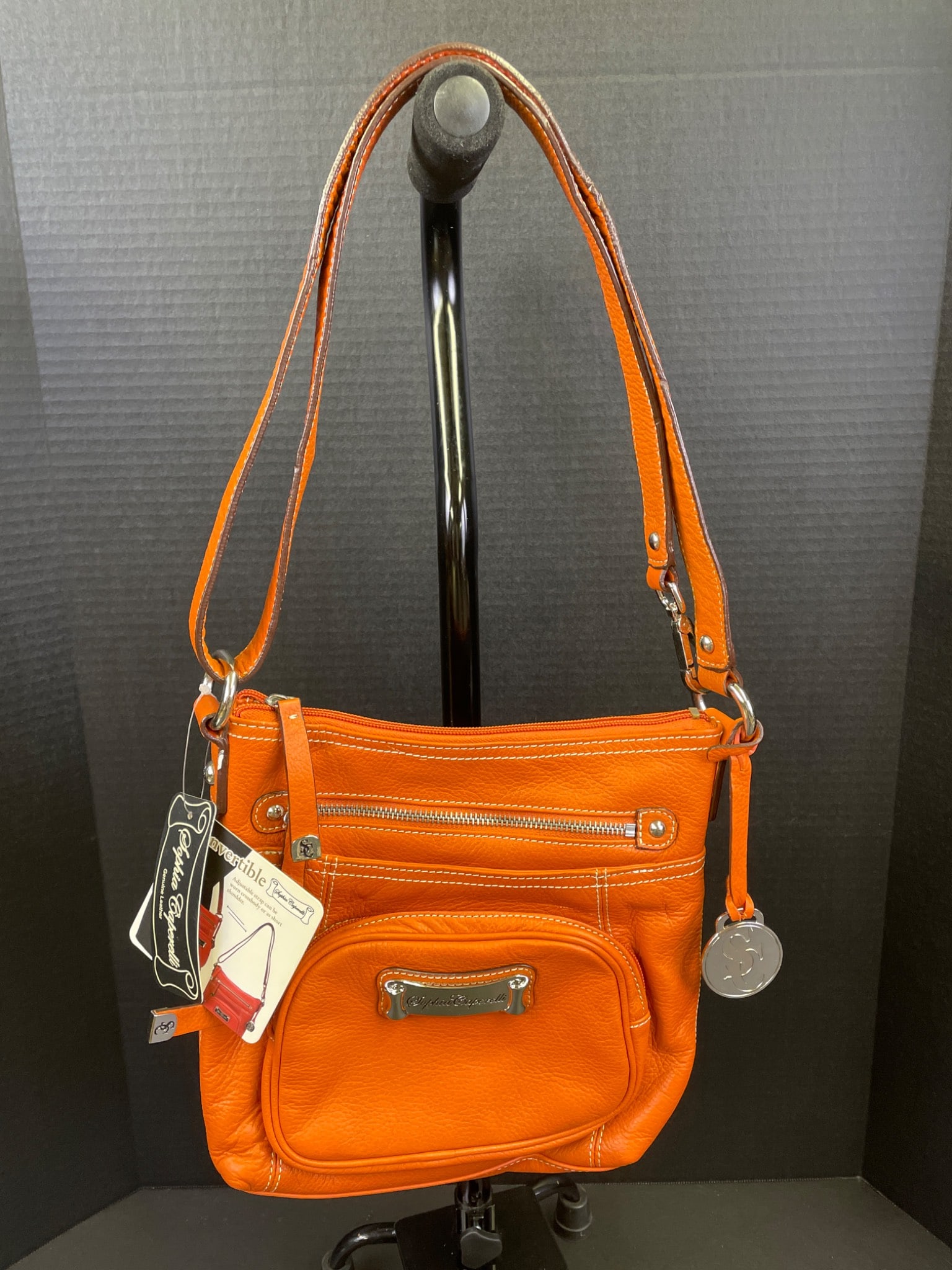 Bright Orange Convertible Leather Crossbody Handbag by Tignanello: This Tignanello convertible handbag is crafted from orange leather and features a crossbody design. It includes two exterior zippered pockets, a rear zippered pocket, and details including a polished