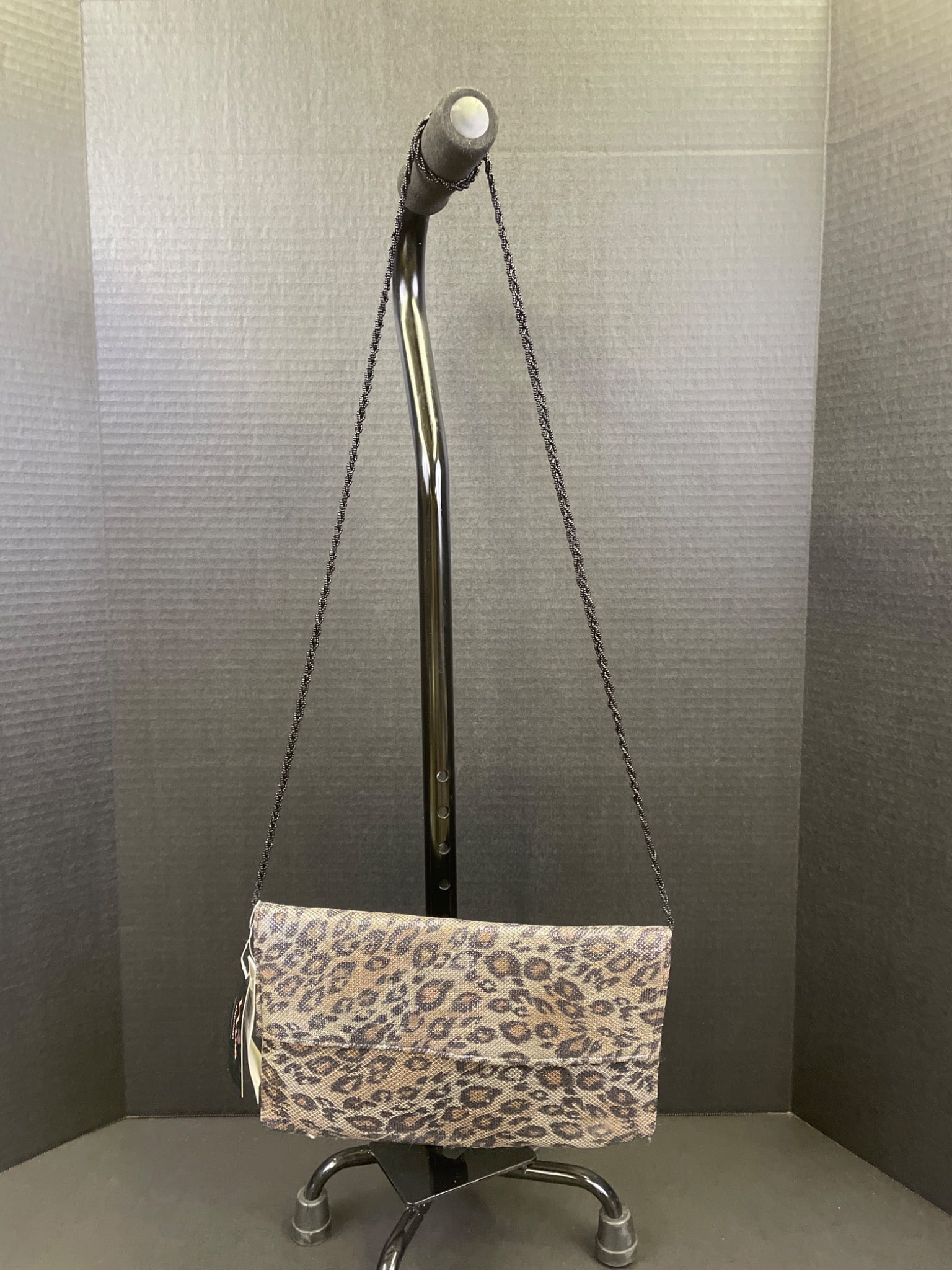 Nina Lennox L Leopard Clutch with Chain Strap: This Nina Lennox L Leopard clutch features a leopard-patterned exterior and a pink satin interior. It includes a removable chain strap for versatile use. Manufactured in China, it retains the