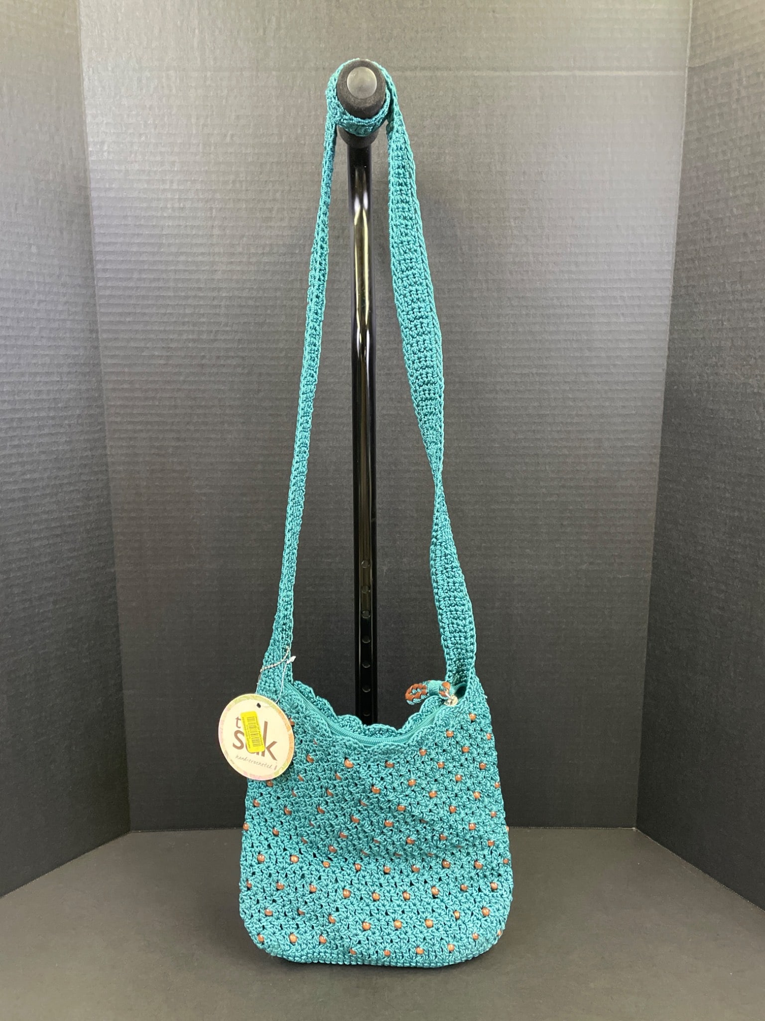 The Sak Casual Classics Style 106119 Azure Beaded Tote: The Sak Casual Classics bag, style number 106119, in azure color with bead accents. Features include an adjustable shoulder strap, zippered main compartment, and lined interior with a brand label.