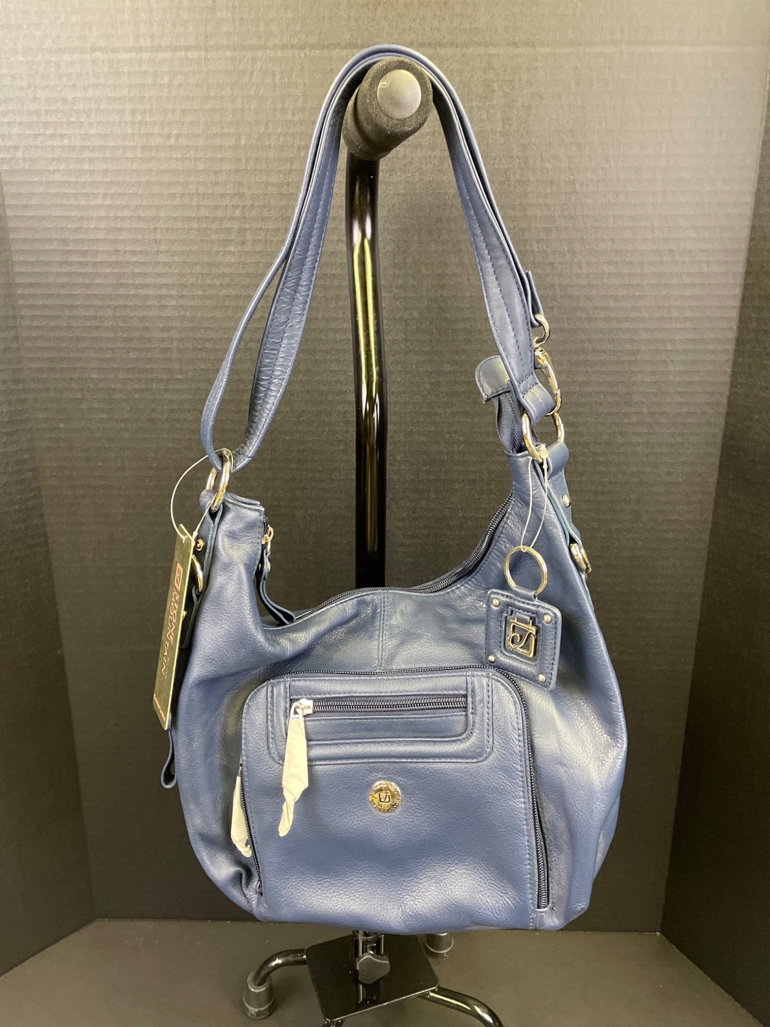 Stone Mountain Genuine Leather Shoulder Bag With Accessories: Stone Mountain genuine leather shoulder bag in blue. Features multiple zippered compartments, a decorative keyring tag, and a patterned fabric interior. Includes a matching wallet cardholder. In