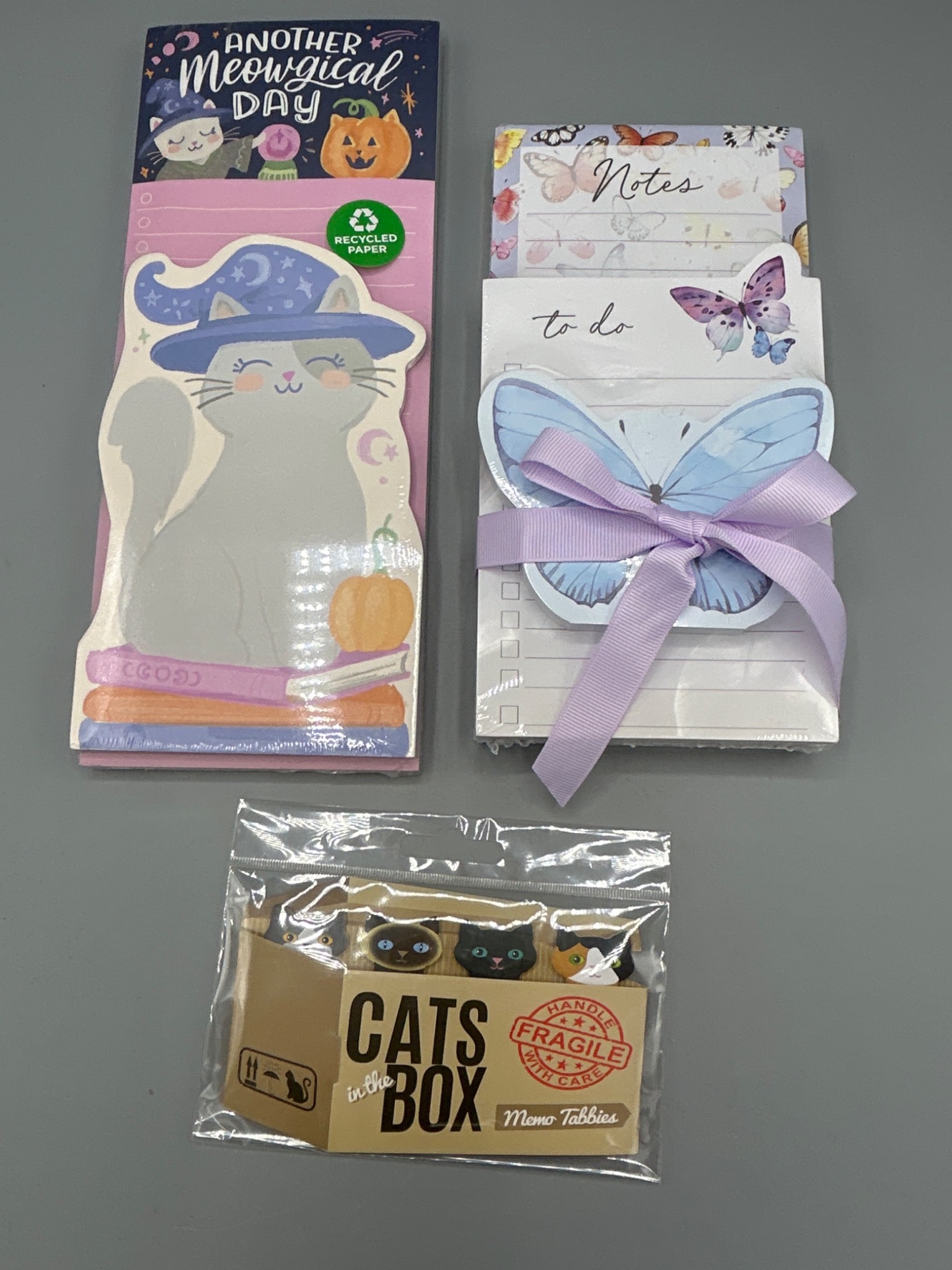 Memo Tab Notes and Sticky Pads Featuring Cats and Butterflies: This lot includes three items: (1) Clementine Paper Inc. magnetic notepad shaped like a cat, made with 60% recycled fiber (Model T670G, manufactured in 2023), (2) a butterfly-themed notepad set tied