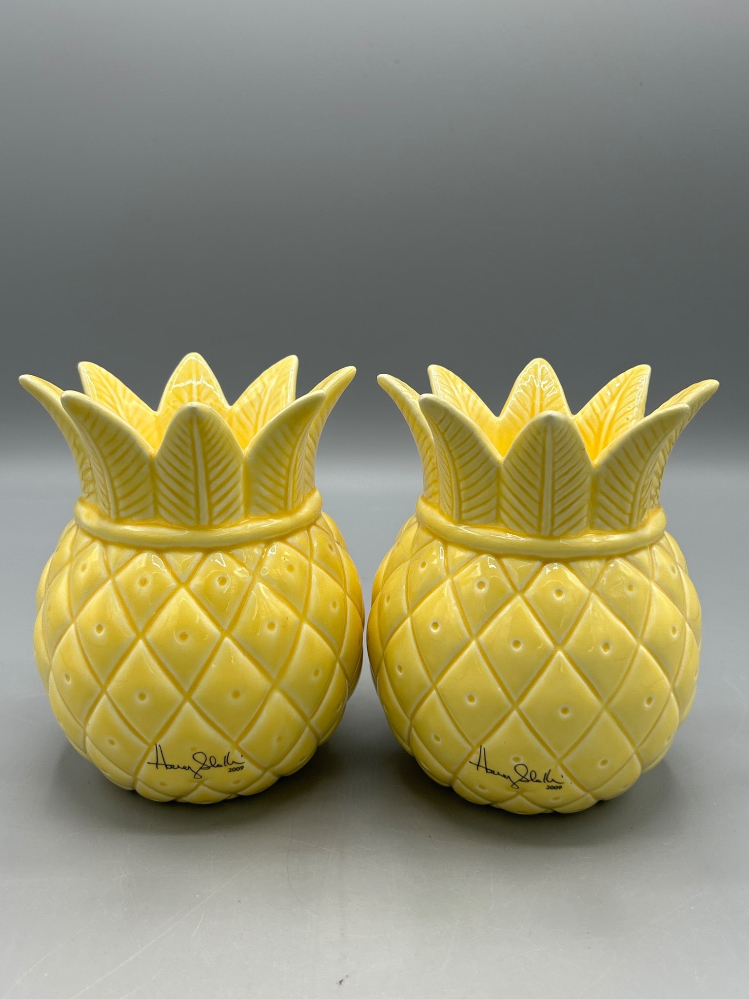 Slatkin & Co Pineapple Scented Candles in Ceramic Containers - 2009: Slatkin & Co scented candles in pineapple-shaped ceramic containers. Scent: Island Nectar. Each candle has a burn time of approximately 30 hours and contains 3.5 oz (99 g). Signed and dated 2009.
