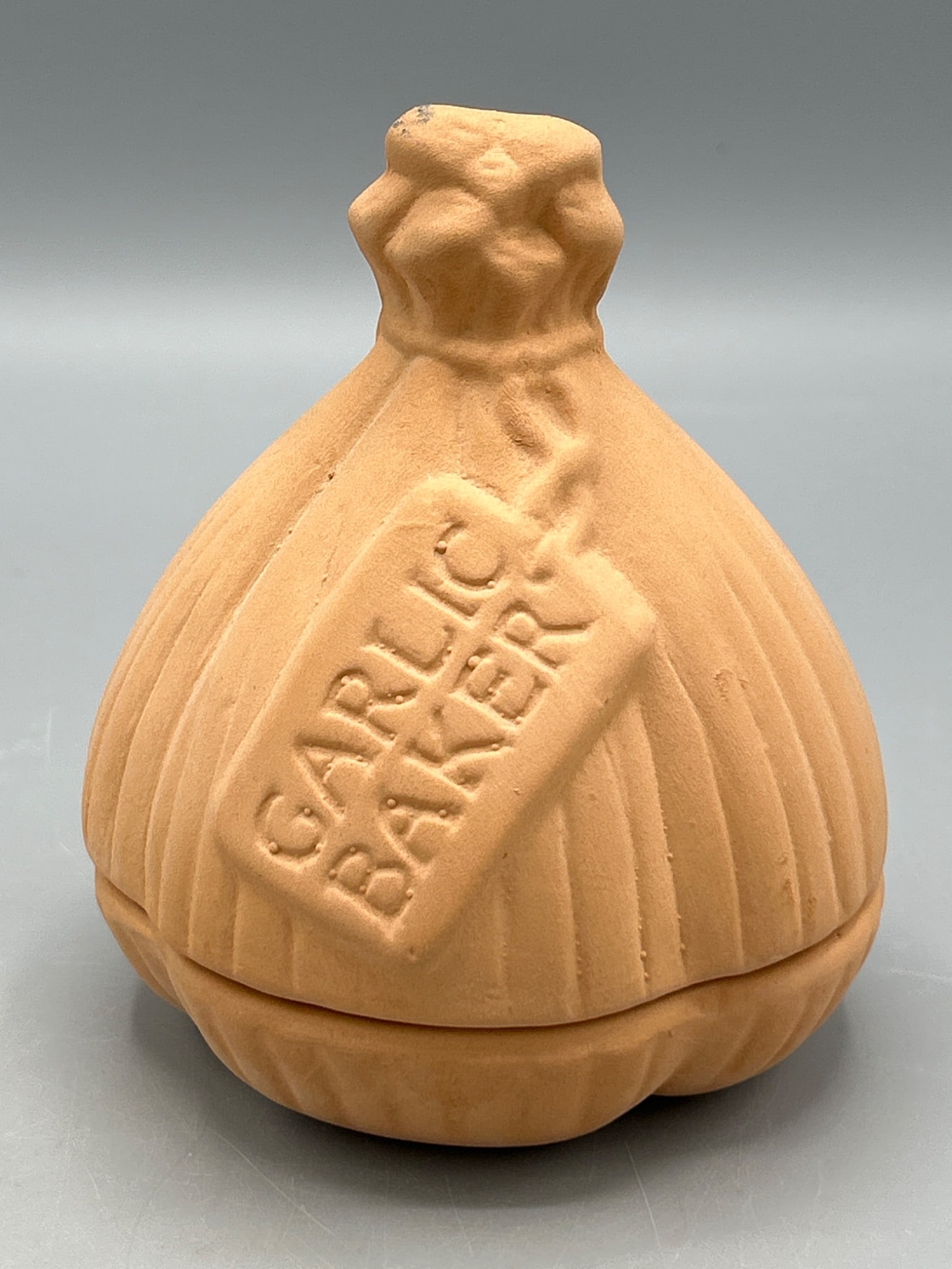 Romertopf Garlic Baker Model Deco Made in Mexico, 1983: Terracotta garlic baker by Romertopf, model Deco, marked 'Mexico' and dated 1983 on the bottom. It features a garlic bulb design with a lid. Approximately 5 inches in height. Has visible marks of