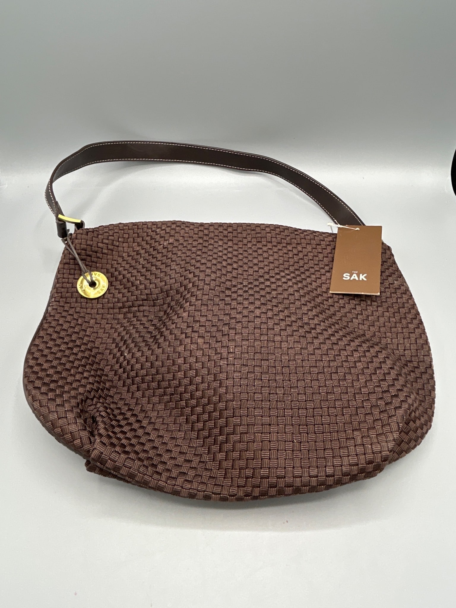 The Sak Everyday Prava 3143BRN Handbag in Brown: This is a woven brown handbag by The Sak, model Everyday Prava, with the model number 3143BRN printed on the tag. The item includes its original tags, showing a suggested retail price of $49. The bag