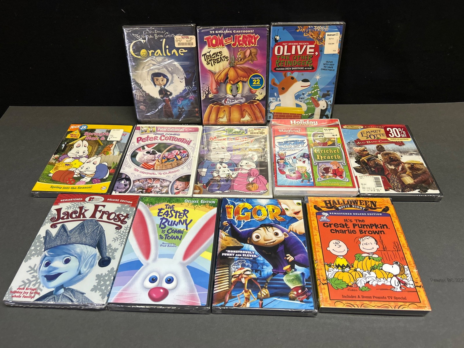 Sealed DVDs Featuring Animated And Holiday-Themed Movies: This lot includes a collection of 12 factory-sealed DVDs consisting of animated and holiday-themed movies and TV specials. Titles include 'Coraline,' 'Tom and Jerry: Tricks and Treats,' 'Olive, The Ot