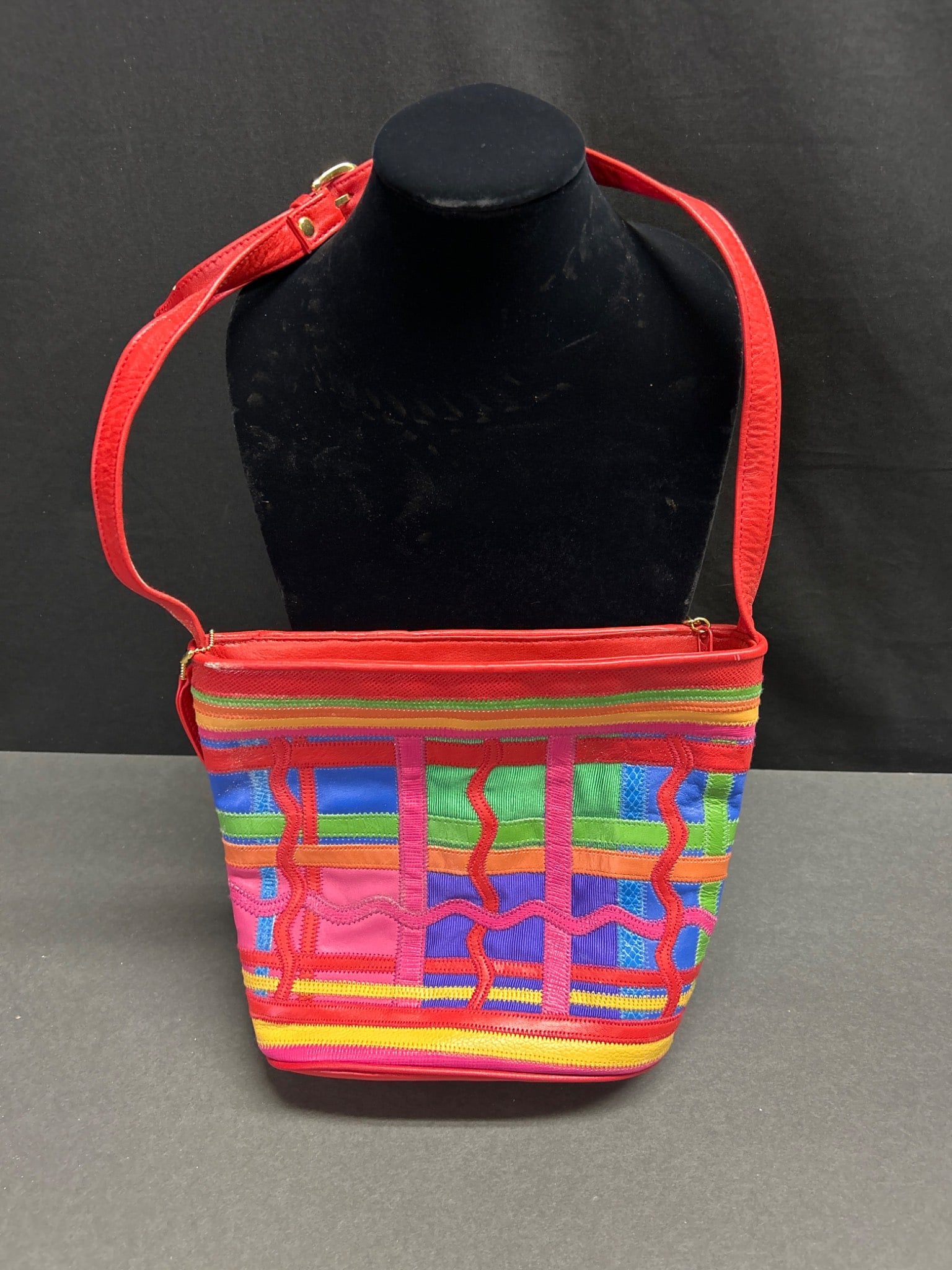 Jacqueline Ferrar Leather and Fabric Shoulder Bag with Multicolor Design: This Jacqueline Ferrar shoulder bag features a multicolor geometric pattern with red leather accents. The bag includes an adjustable leather strap, a zippered main compartment, and an interior label
