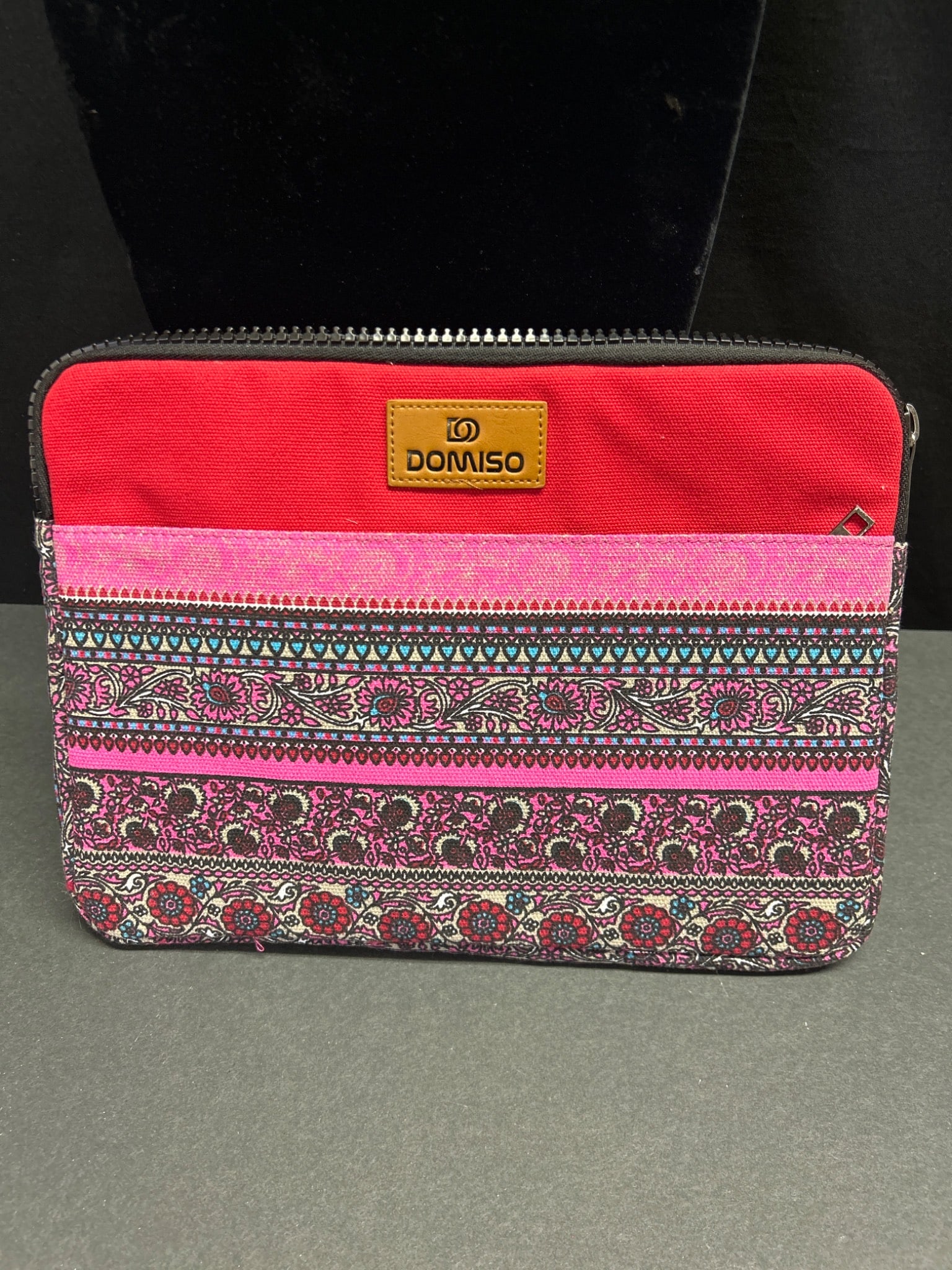 Domiso Multi-Color Fabric Zipper Pouch with Interior Lining: Domiso branded zipper pouch featuring a multi-colored patterned fabric exterior in shades of red and pink. The interior is lined with a cream-colored material. The pouch measures approximately 10 x 8