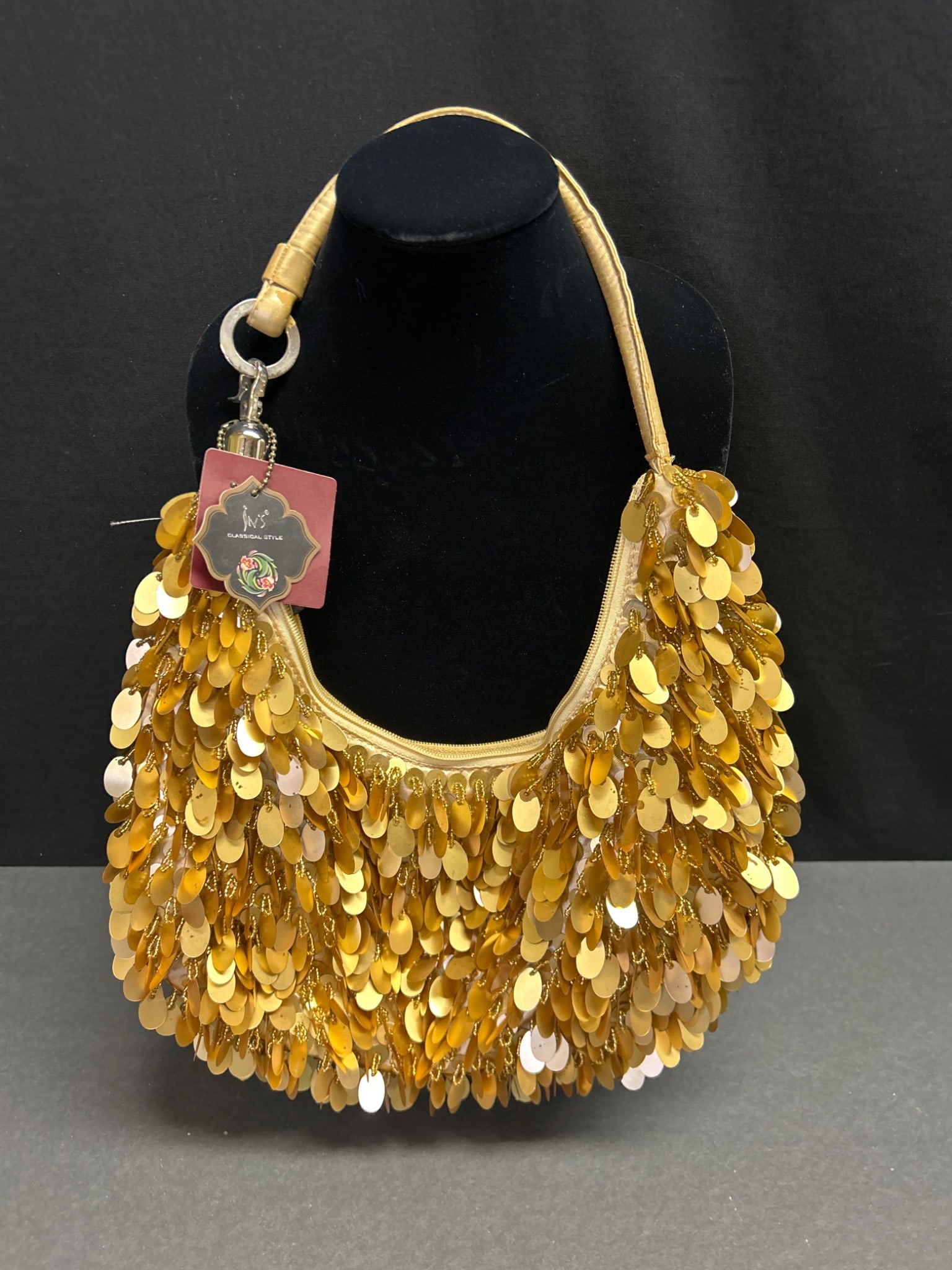Ins Classical Style Handbag With Gold Sequins and Satin Lining: Ins Classical Style handbag featuring gold-toned sequins on the exterior and a gold satin interior. The bag includes a single handle and a zippered top closure. Attached is the original tag with